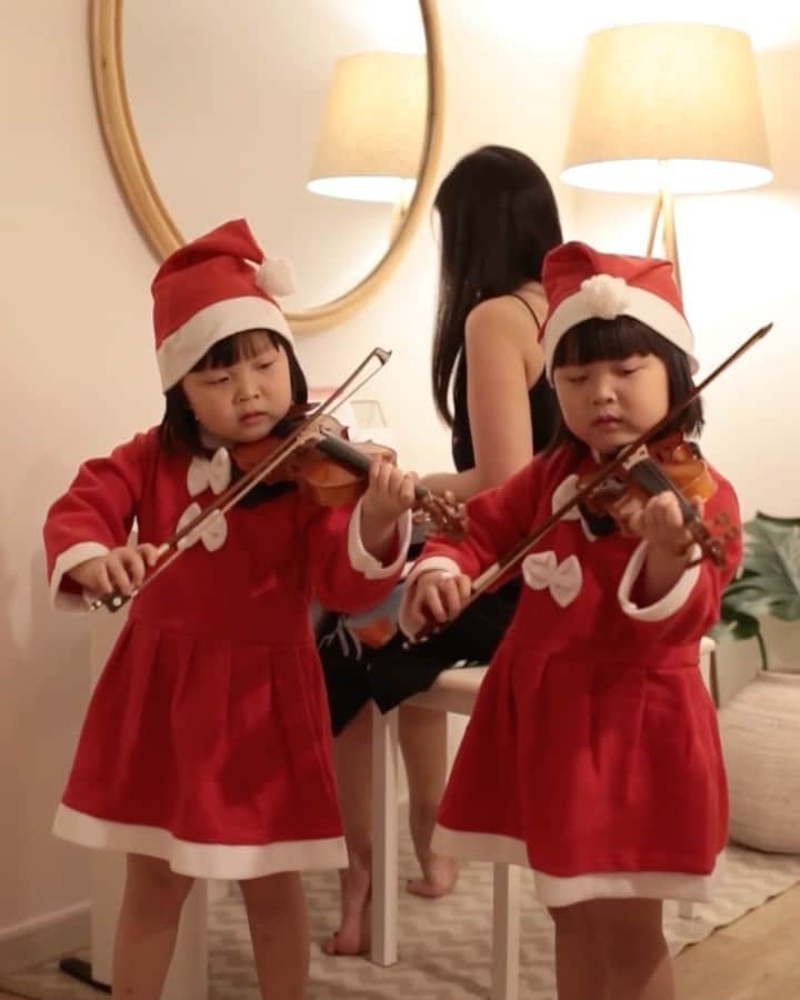 MOMOツインズのインスタグラム：「Looks like Luke found the secret Christmas channel! Tuning in to Jingle bells, brought to you by Leia and Lauren 🎄  The girls recently started their violin lessons at @wolfgangviolin , just in time to bring us a little Christmas cheer. Leia has been teaching me the piano piece that she learnt from @joywaltzacademy too, and clearly I need help 😆  #christmas2020」