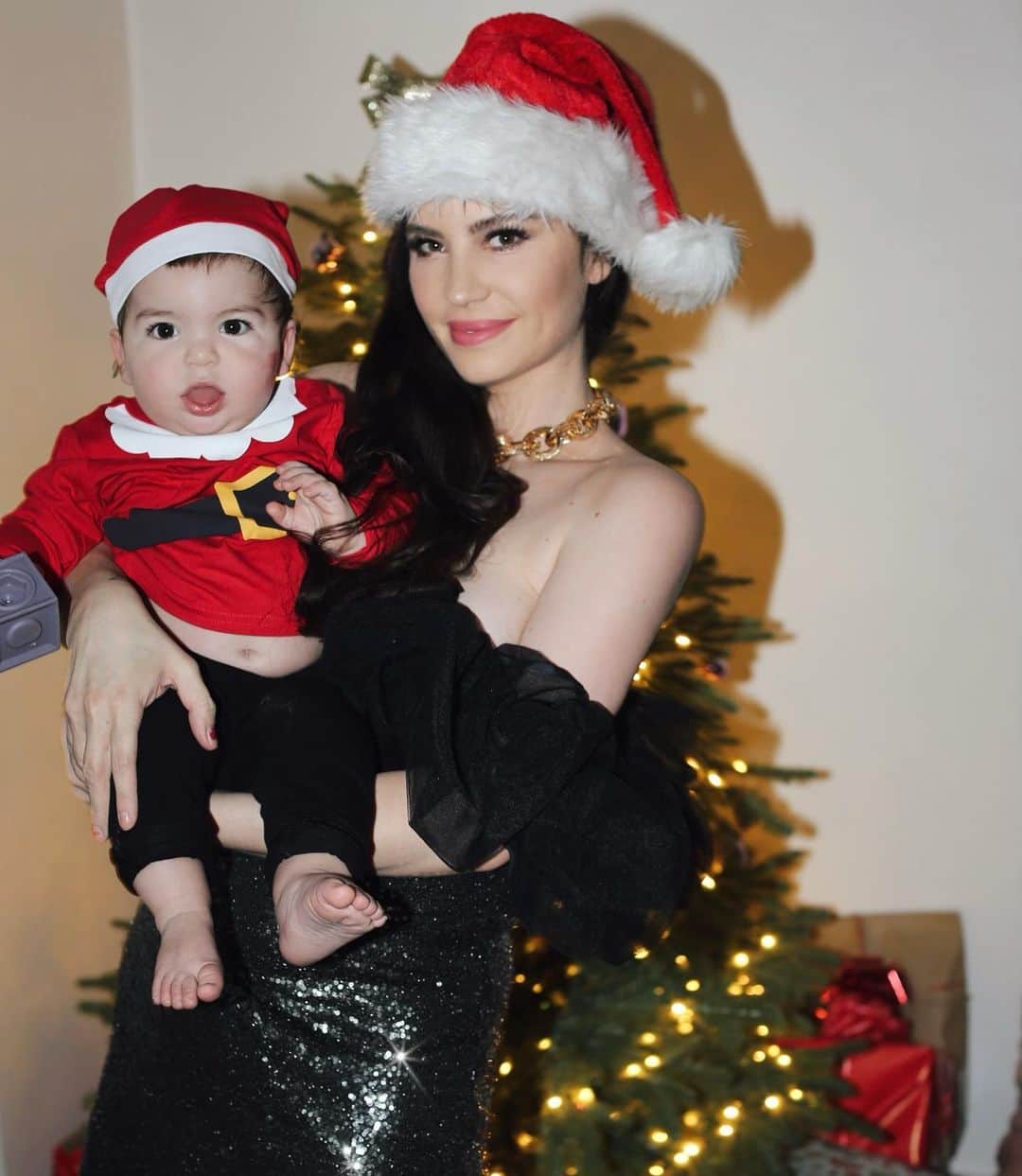 ベティ・オウティエのインスタグラム：「Hohoho! 🎅🏻 Premier noël avec Mars, je suis particulièrement émue, j’ai adoré cette fête étant enfant, en devant adulte elle était devenue moins magique, et la d’un coup tout reprend son sens !🎄  On a mille cadeaux sous le sapin et je ne tiens plus en place !!🎁  On est tous les deux habillés en @hm pour l’occasion! Mars en petit père noël 🎅🏻et moi avec cette robe à froufrous / sequins 🧑🏻‍🎄! Parfait combo !  Je vous embrasse fort fort fort! Je vous souhaite un joyeux réveillon!  #HMxME」