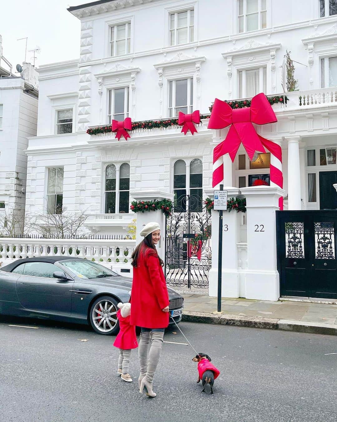 ペオニー・リムのインスタグラム：「Merry Christmas 🎄 Wrapped up in a bow. When this little red coat came from @moncler for Thumbelina (gifted) I just couldn’t resist doing a photo like this. We often walk the street this house is on during Christmas to see the decorations and when I saw this house I knew it was perfect for the photo. With a little help from @tilfrances we got the photo!  #mummalim #peonylimstyle #peonylimchristmas #monclerdogs」
