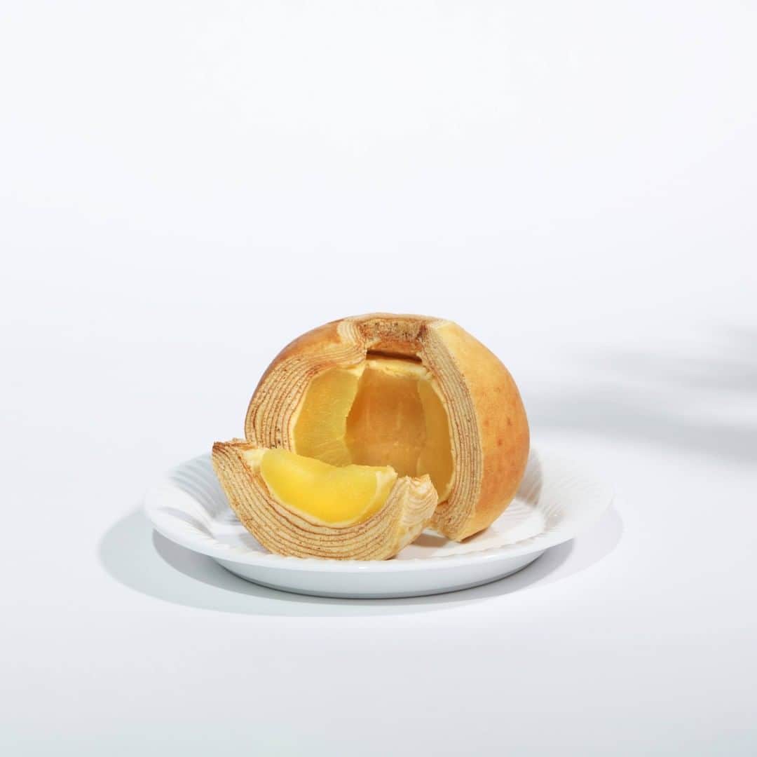 ユーハイム公式さんのインスタグラム写真 - (ユーハイム公式Instagram)「【アッフェルバウムを切ってみると。。。】  さてさて、ついにアッフェルバウムが完成。さっそく食べてみましょう。 カットすると蜜色の半透明のりんごが現れました。りんごの部分はしゃくっと、しっかりと食感はありつつ、水分もしっかり。それは、バウムクーヘンの生地で包んで蒸し焼きにしているからでしょう。蜜が焼けた、キャラメルのような香りも特徴的。バウムクーヘンの生地にも、りんごの蜜が浸透して、しっとりとしているものアッフェルバウムのおいしさの秘密です。  東北地方で育ったおいしいりんごが手作業できれいにカットされ、シンプルなシロップで漬け込まれ、バウムクーヘンに包まれて焼きあがるまで、いかがでしたか？  ほんのちょっとのシナモンと、バニラアイスを添えたら、立派なデザートですね。 アッフェルバウム、ぜひお楽しみくださいね。  #りんご #🍎 #アッフェルバウム #アッフェル #ユーハイム #バウムクーヘン #りんごのお菓子 #お菓子作り #純正自然 #ふじ #ふじりんご  #apple #apfel #baumkuchen #apfelbaum #juchheim」12月25日 21時00分 - juchheim1909