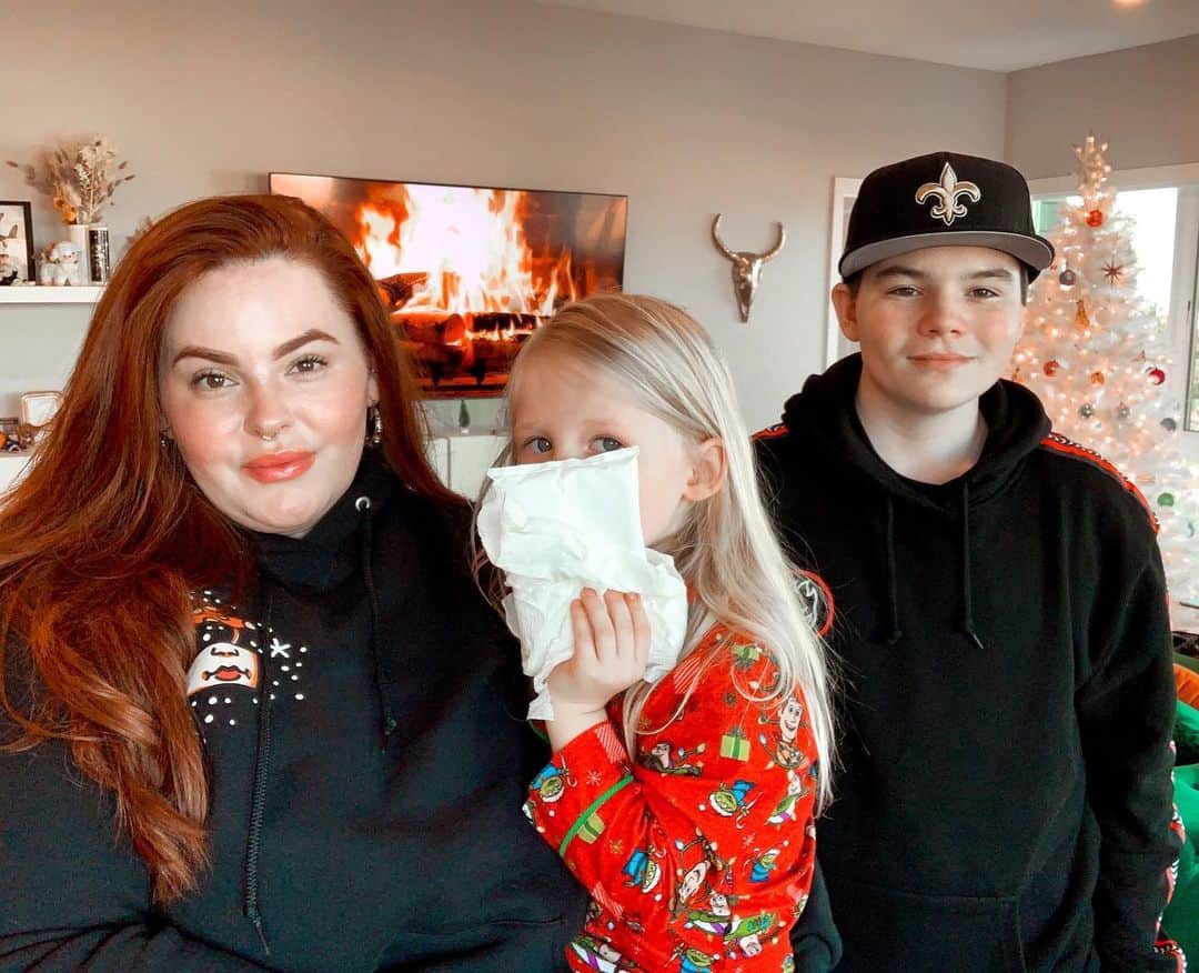 テス・ホリデーのインスタグラム：「When all you want for Christmas is a family photo but your toddler decides to jump on the couch despite you telling him not 1000x & mins before your photo he falls down & busts his mouth open & bleeds all over your brand new pink outfit that you were gonna wear while holding a wine glass & channeling the mom in Mean Girls. *sigh* After I made sure he didn’t need to go to urgent care, I threw my blood stained clothes away, took my bra off & put on comfy clothes & asked the boys if they still felt like taking a photo, & this is what we got LOL. Sometimes you just have to laugh at the universe, I got my photo, it just wasn’t as “cute” & “perfect” as I hoped for. I am grateful that my cool almost 15yr old finally gave me permission to post a photo of him though. Little victories. Anyway, Merry Christmas y’all 🤣🎄♥️✨」