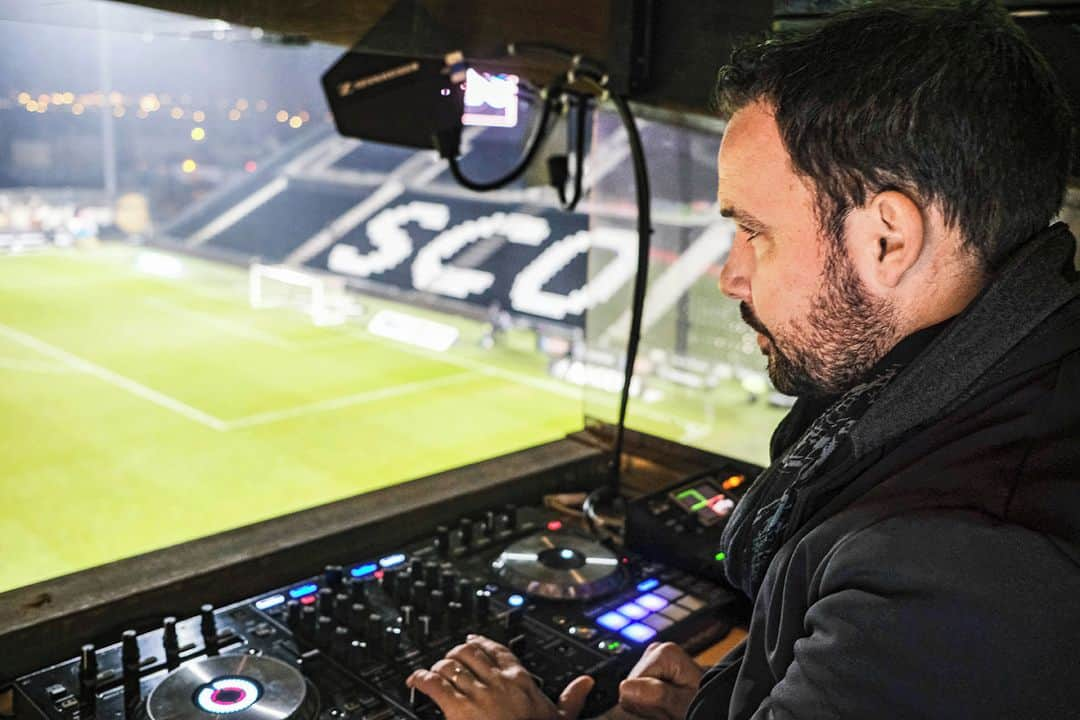 ルモンドさんのインスタグラム写真 - (ルモンドInstagram)「Dans les travées du stade Raymond-Kopa, à Angers, une banderole déployée lors du match précédent est restée en place. « Gagnez pour vos supporteurs confinés », encourage-t-elle. Ce mercredi 16 décembre, le SCO Angers affronte le RC Strasbourg pour le compte de la 15e journée de Ligue 1. Et, comme depuis le début du deuxième confinement, les noir et blanc jouent dans leur enceinte totalement vidée de leur public. Alors, le club de football du Maine-et-Loire a pris une drôle d’initiative pour pallier l’absence de chants depuis trois matchs : diffuser une bande sonore qui reproduit l’atmosphère sonore habituelle du stade.⁣ Anthony Doéli, 38 ans, responsable de l’animation visuelle et sonore, est installé dans une petite cabine à côté de la tribune presse. Depuis neuf ans, il s’occupe de l’affichage sur l’écran géant et des animations d’avant-match à base de musique commerciale diffusée à fond.⁣ « Les premières rencontres à huis clos ont été compliquées à vivre, se souvient-il. On entendait juste les joueurs et les entraîneurs crier. On avait juste l’impression d’être à l’entraînement. On ne pouvait pas rester comme ça. » En accord avec le club, le DJ se lance dans des travaux qui lui prennent deux journées complètes. Il récupère plusieurs matchs des saisons précédentes, mis à disposition par la Ligue de football professionnel (LFP). « J’ai notamment choisi ceux où les supporteurs adverses avaient été interdits de déplacement », indique-t-il. Il prend alors divers petits échantillons sonores de matchs qu’il mixe afin d’obtenir une bande-son de cinquante-cinq minutes. La LFP a autorisé ces nouvelles initiatives à condition qu’elles ne contiennent pas d’insultes, ni de sifflets. Un délégué est présent à chaque �rencontre pour s’assurer que ces règles sont respectées.⁣ -⁣ Anthony Doéli dans sa guérite au stade Raymond Kopa d’Angers, le 16 décembre. Photo : Jean-Michel Delage / Hans Lucas (@studiohanslucas) #PourMleMagazineduMonde (@m_magazine)⁣ -⁣ #football #covid19 #Angers」12月26日 16時27分 - lemondefr