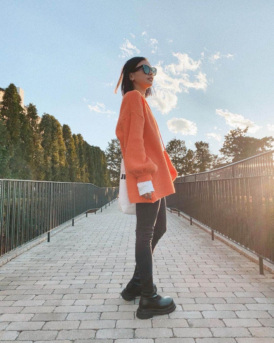 馬詰まほのインスタグラム：「orange vibes🍊🤍 今年の年末から年越しまでは 家族みんなでおとなしく過ごします☺︎ 今というかけがえのない時間を大切に。 大好きなオレンジのニットを着てたそんないつかのコーデ写真📸 tops / @openclose_official」