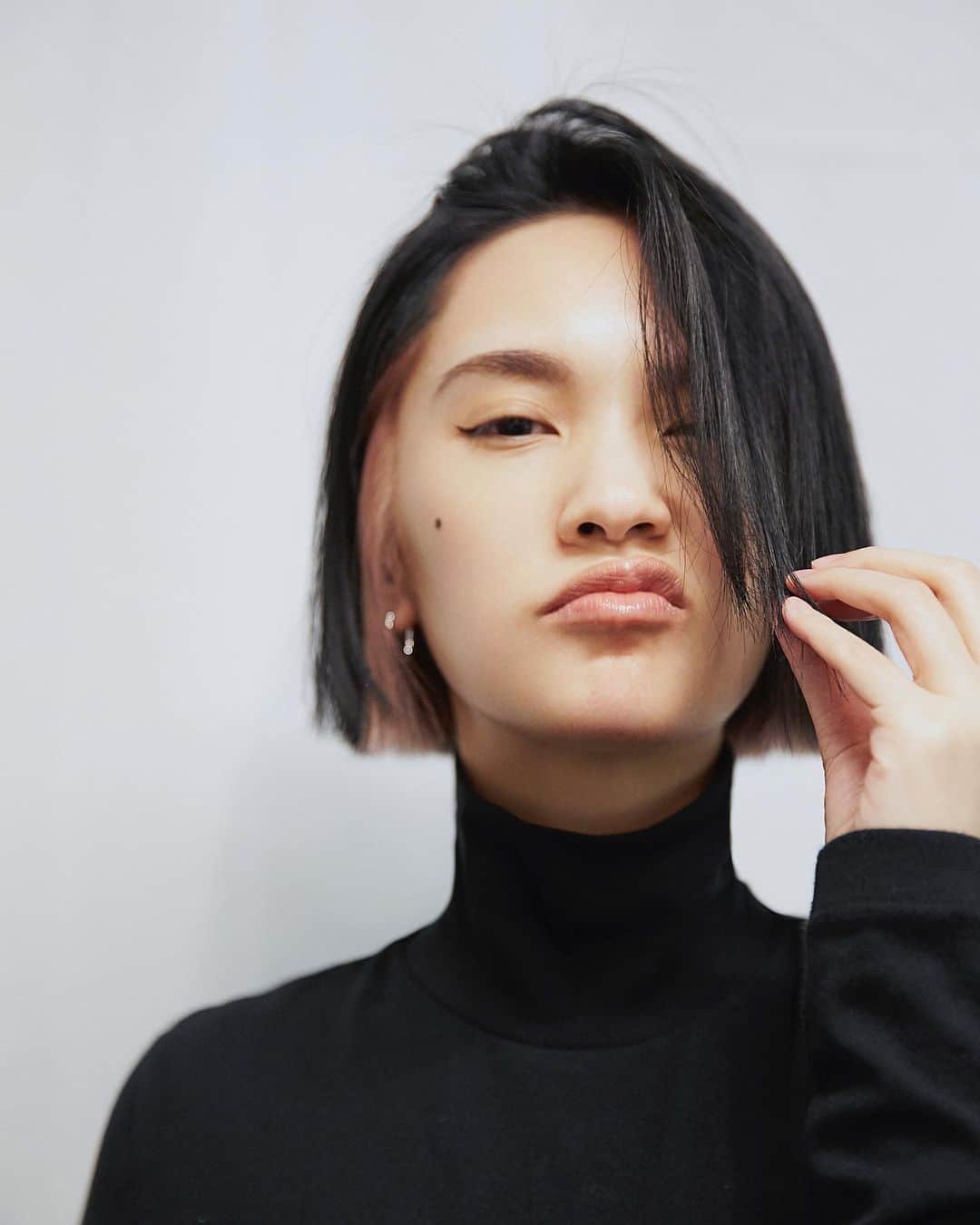 レイニー・ヤンのインスタグラム：「喔耶！我換髮型了✌🏻 想說，專輯宣傳已結束，外加2020快過去，好像可以換個造型來轉變一下心情😌 這次的顏色要整慘我，因為先前是外淺內深，現在改為外深內淺，也就是乾坤大挪移的狀態，因此漂色的部分非常耗時😪 染髮由淺入深易，由深入淺難，昨天和今天相加，共花費了9小時處理，坐到我屁股都要爛了，不過很值得啦😙然而熱愛短髮的我，當然得趁機把頭髮再往上剪一剪啦！雖說冬天時脖子很怕冷，但也因為頭髮夠短，反而穿高領更加好看了呢🥰 Anyway～可以感覺到我暫時不會把頭髮留長，對吧？我想，你們早已習慣了千變萬化的我，不意外的話，不久的未來，還會再有新髮型的出現喔😆我個人很期待！  Photographer： @kevinim   💇🏻‍♀️髮色給你/妳知： 外層：墨色 內層：裸玫瑰金色  P.S. 謝謝安妘特地到髮廊一趟，為我化上兩條眼線😘  #新髮型 #新髮色 #新樣貌 #耳圈染  #其實我還想剪得更短 #甚至猶豫是否要剪瀏海 #最後為了不要看起來年紀太小 #於是放棄把額頭遮住的機會」