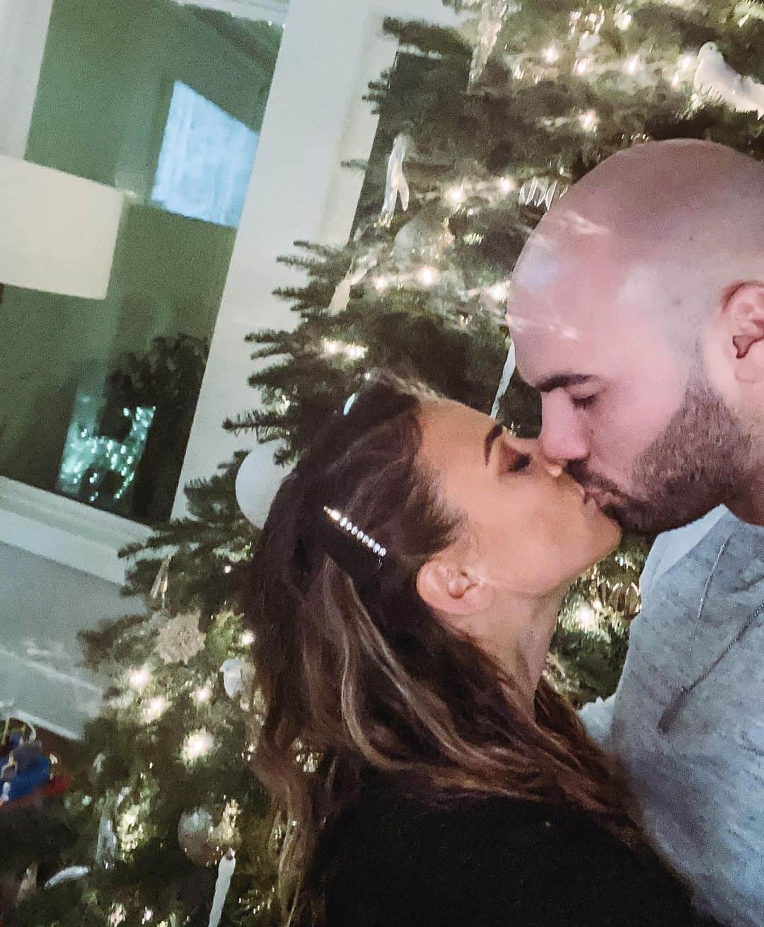 のインスタグラム：「Last kiss by the Christmas tree.  I took all the decorations down today but the tree goes tomorrow. Am I the only person who takes everything down the day after Christmas?!? 😂」