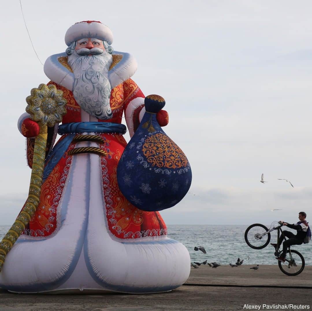 ABC Newsさんのインスタグラム写真 - (ABC NewsInstagram)「A cyclist performs a trick on an embankment near an inflatable figure of Ded Moroz, the Russian equivalent of Santa Claus, in the Black Sea resort of Alushta, Crimea.」12月29日 3時30分 - abcnews