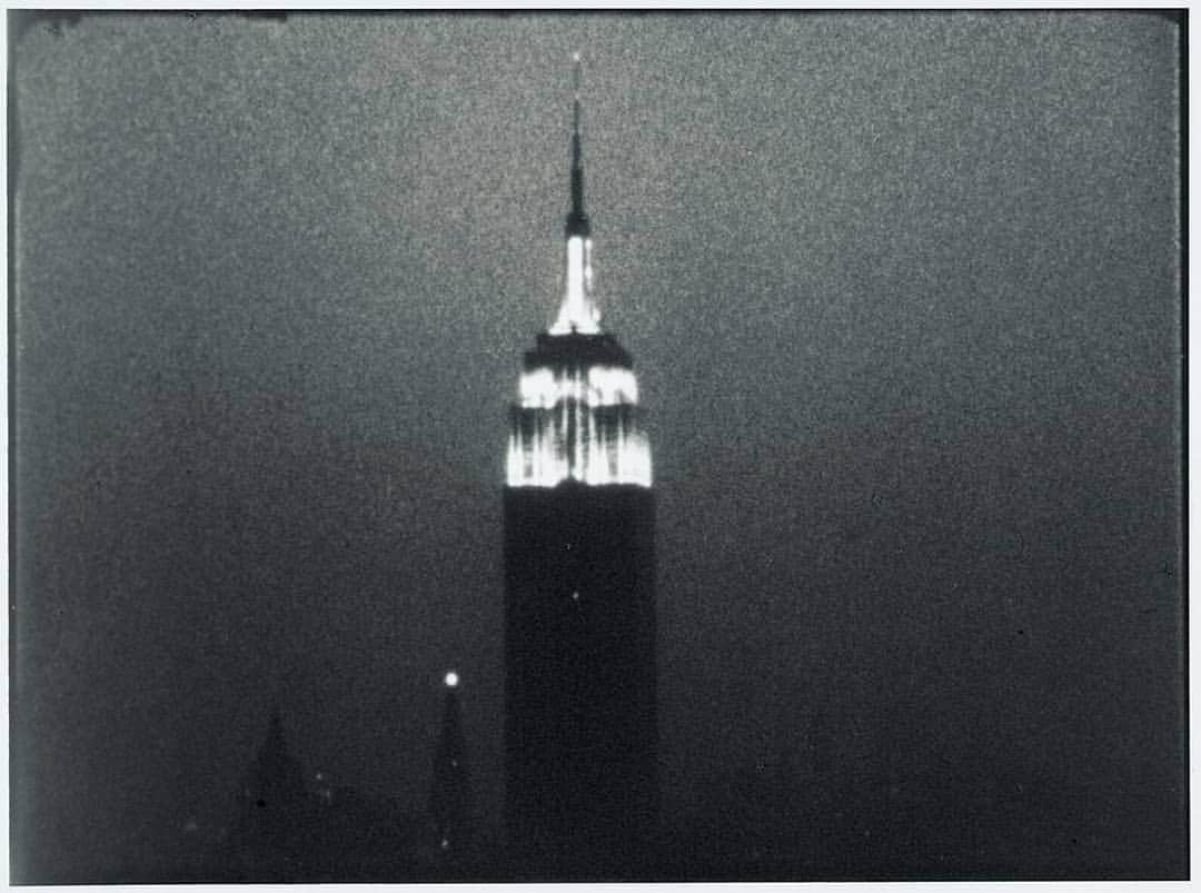ニューヨーク近代美術館のインスタグラム：「Film curator @scavoulacos made us a playlist inspired by #AndyWarhol’s landmark eight hour-and-five-minute film, "Empire," now on view in our galleries.  "In a year that has transformed our relationship to the passage of time," Cavoulacos's "songs for a slow city" invite deep listening and ambient interludes, ideal for taking in Warhol's epic black-and-white film, comprising a single fixed frame of the iconic New York City skyscraper. Start listening at the link in our bio. --- [Andy Warhol. "Empire." 1964. Digital transfer of 16mm film (black and white, silent). The Museum of Modern Art, New York, 1993. Courtesy The Andy Warhol Museum, Pittsburgh, and The Andy Warhol Foundation for the Visual Arts, Inc.]」