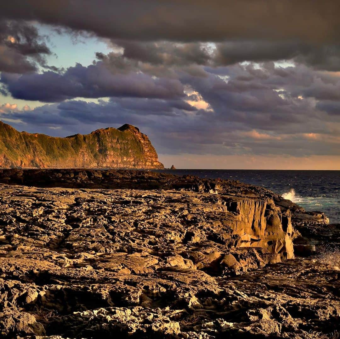 林信行さんのインスタグラム写真 - (林信行Instagram)「An afternoon in Hachijo Island. #八丈島 の夕べ あまりの自然の美しさに一目惚れしました。 初めての八丈島滞在は3時間半。飛行機のマイレージプログラムとかに詳しい人に「250PP必要だった」と言えばピンと来るようなくだらないきっかけだったのですが(まあ、でも12月は本当に忙しかったので、これくらいの遊びは許してくださいー苦笑)、一番飛行時間短く行けそうだからと、全都道府県制覇して、次は「島」に目をつけていることもちょっとあって行ってみたら、あまりの美しさにやられてしまいました。最初は歩いて空港の周りだけでいいや、と近くのお蕎麦屋さんまで行き、そこから延々と1時間以上、タクシー捕まらないからと北側の港まで歩いてしまいました。その後、夕陽が落ちるのは反対側だと気がつきタクシーを呼び、運転手さんに「夕陽がきれいなところまで」と頼んで連れてきてもらった南原千畳岩海岸の夕陽も景色もあまりに美しく、次はもっと長く滞在しよう！と思っちゃいました。 ちなみに空港の外で半径5m以内に近寄った人は蕎麦屋のおじさまと、タクシーの運転手さんだけ。 全然、人とすれ違わないと思ったら、当然ながら皆、車だからなんですね。海岸まで歩いたと言ったら驚かれました😉  #畑中葉子　さんに3.5時間にしてはルートが完璧過ぎると驚かれましたが、次回はぜひ山の方にも攻め入りたい！  #HachijoIsland #八丈島 #shotOniPhone12ProMax (edited using built in features)」12月30日 0時10分 - nobihaya