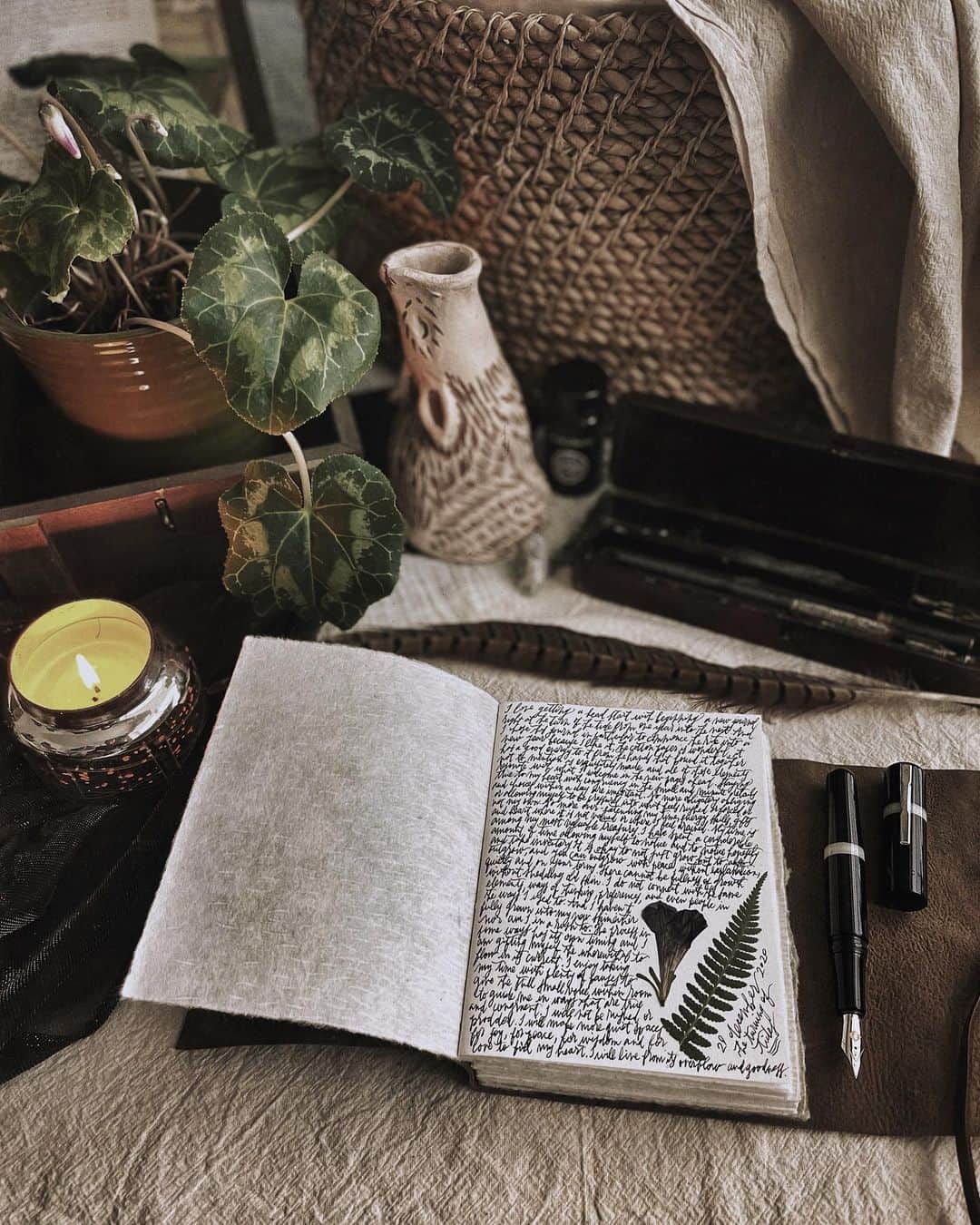 Catharine Mi-Sookさんのインスタグラム写真 - (Catharine Mi-SookInstagram)「Commencing a journal at the turn of the tide and the precipice from one year to the next. I prefer starting new pages and books right in the turning. There is a magic in that space. Hibernation mode is fully afoot and I am enjoying the extra quiet to attune to the still and small within the heart. Lots of noticing in the musings of late, much without judgment one way or another, more just taking note and adjusting the chords for a lovely harmony. In the noticing I’ve discovered how uncharted notions can turn things sideways and upside down. Things that I feel I should like, I’ve discovered I really don’t. Other areas where I feel like I should feel good in connection to whatever it is, I find myself feeling drained. In the growing, there is a quiet outgrowing. Sometimes I hardly notice it until one day things just don’t fit anymore and are quite uncomfortable. In this particular turn of seasons, I’ve let be with it and dare I say enjoy it. It’s a fruitful process and one that’s been nourishing and filling. I don’t have all my ducks lined up for the new year and I’m taking things slow. No more rushed pressure or prodding, but rather mindful strides with pauses and noticing, attuning and adjusting, with much gratitude in the laying down and opening anew. . . . . Model 19 Fountain Pen & Black Cherry Ink @franklinchristoph. Leather Handmade Journal w/ cotton paper @quillandarrow. Ceramic Wolf Incense Burner #mypitchpine @pitchpinepottery. Luna Alpha Ring @foxand.thefawn. . . . . #journaling #journalinspiration #memoirs #franklinchristoph #fountainpens #penmanship #quillandarrow #bookbinding #handmadejournal #pitchpinepottery #booksandcandles #foxandthefawn #metalsmithing #creativespace #darkacademiaaesthetic #darkandmoody #candlelovers #anthropologiehome #capturequiet #beautyofstillmoments #cozycorner #daysofsmallthings #livemoremagic #lightacademiaaesthetic #abmathome」12月30日 4時20分 - catharinemisook