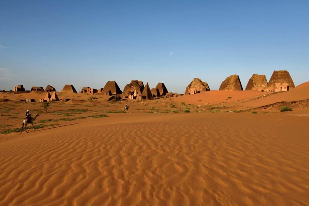 National Geographic Travelさんのインスタグラム写真 - (National Geographic TravelInstagram)「Photo by Robbie Shone @shonephoto / Late afternoon light as two camels and riders pass in front of the line of pyramids at Meroë, Sudan. Strong winds create fresh ripples in the sand. It is here at Meroë, in about 300 B.C.E., where Kush leaders were forced to build their capital, following increasing pressure from the Egyptians. The steep-sided pyramids were built over the burial chambers of the rulers. These pyramids were infamously plundered by Italian explorer Giuseppe Ferlini in 1834.」1月14日 4時36分 - natgeotravel