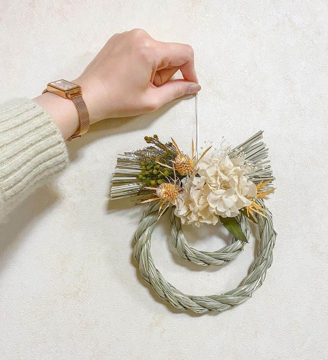 ドーキンズ英里奈のインスタグラム：「お正月飾り🎍 ⠀ 100均のしめ縄にプリザーブドフラワーをつけて モダンな感じにDIYしてみました◎ ⠀ ⠀ まずはお花を並べてみて、 好きな感じに組み合わせてから ⠀ グルーガンを使って、 しめ縄にぺたぺたつけていくだけ とっても簡単です。 ⠀ ⠀ グルーガンは子どもの頃からよく 工作のときに使っていたけれど 2020年はコスプレに結婚式アイテム作りに 大活躍してくれました〜👏 ⠀ ⠀ ⠀ 時計は @4bwatches_japan の クリスマスギフト🎄 盤面がシンプルでピンクゴールドが可愛い。  10%オフになるクーポンあるから よかったらどうぞ👉🎟erinalo173  ⠀ ⠀ ⠀ ⠀ #お正月飾り#しめ縄#しめ縄アレンジ#しめ縄作り#しめ縄飾り#4bwatches #腕時計 #時計 #brackbybruebrave #クリスマス #クリスマスプレゼント #ギフト#メイドバイドキン」