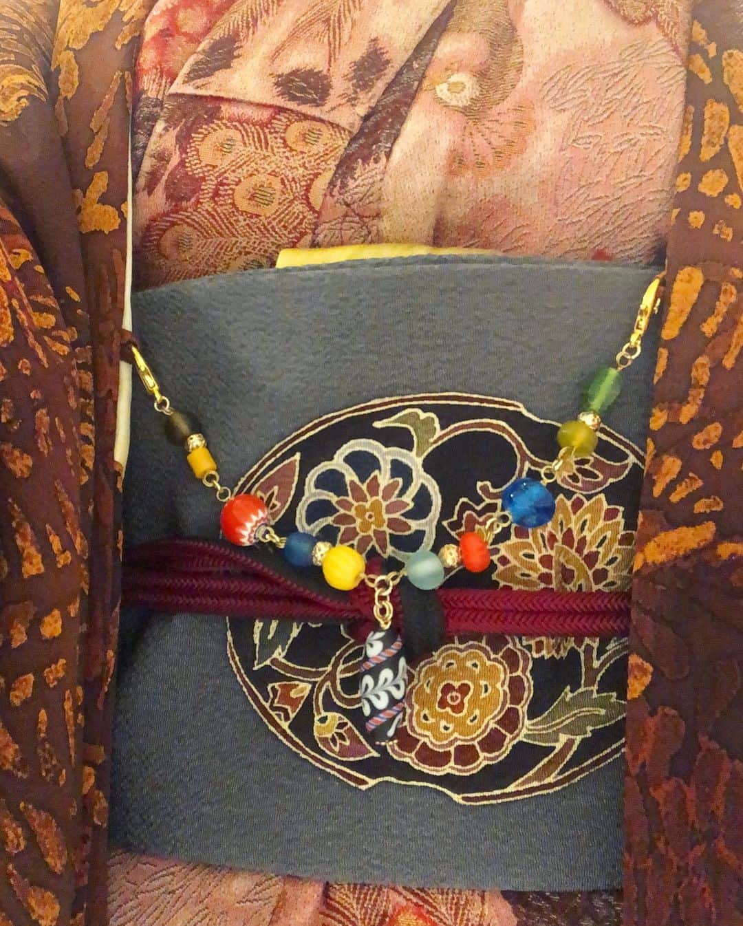 岡田育さんのインスタグラム写真 - (岡田育Instagram)「I would like to try every category of casual kimono, and here comes my new/secondhand Omeshi kimono. Indian peacocks and hibiscus from South Asia meet Chinese style flowers on a obi belt, and Tibetan beads bridge them to Japanese fence pattern on a haori jacket. . 🦚🌺🦚🌺🦚 . カジュアル着物界隈ひとまず一周してみたくて、初銘仙、初江戸小紋、初紬に続き、初お召。あんまり状態よくない古着ですが、いやインドクジャクに仏桑花（ハイビスカス）ですよ、箪笥の桃源郷で孔雀を飼う暮らし最高だろ。羽織紐はチベタンビーズ。せっかく久しぶりに昼の自然光で撮った全身写真が道端でゴミ袋さげてるようにしか見えない。信号待ちに暑くて脱いだユニクロのジャケットです。 . #👘🔰 #御召 #お召 #小紋コーデ #大人ピンク #羽織コーデ #名古屋帯 #唐花 #仏桑花 #孔雀柄の着物 #ハイビスカス柄 #着物女子 #着物好き #着物生活 #omeshi #kimono #kimonostyle #japanesekimono #vintagekimono #kimonopattern #kimonogirls #kimonogram #peacockdress #hibiscusdress #dailydresses #casualkimono #岡田育 #ikuokada」1月4日 12時51分 - okadaic