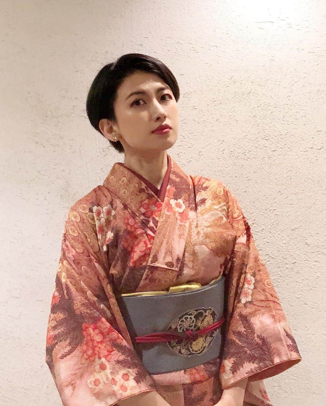 岡田育さんのインスタグラム写真 - (岡田育Instagram)「I would like to try every category of casual kimono, and here comes my new/secondhand Omeshi kimono. Indian peacocks and hibiscus from South Asia meet Chinese style flowers on a obi belt, and Tibetan beads bridge them to Japanese fence pattern on a haori jacket. . 🦚🌺🦚🌺🦚 . カジュアル着物界隈ひとまず一周してみたくて、初銘仙、初江戸小紋、初紬に続き、初お召。あんまり状態よくない古着ですが、いやインドクジャクに仏桑花（ハイビスカス）ですよ、箪笥の桃源郷で孔雀を飼う暮らし最高だろ。羽織紐はチベタンビーズ。せっかく久しぶりに昼の自然光で撮った全身写真が道端でゴミ袋さげてるようにしか見えない。信号待ちに暑くて脱いだユニクロのジャケットです。 . #👘🔰 #御召 #お召 #小紋コーデ #大人ピンク #羽織コーデ #名古屋帯 #唐花 #仏桑花 #孔雀柄の着物 #ハイビスカス柄 #着物女子 #着物好き #着物生活 #omeshi #kimono #kimonostyle #japanesekimono #vintagekimono #kimonopattern #kimonogirls #kimonogram #peacockdress #hibiscusdress #dailydresses #casualkimono #岡田育 #ikuokada」1月4日 12時51分 - okadaic