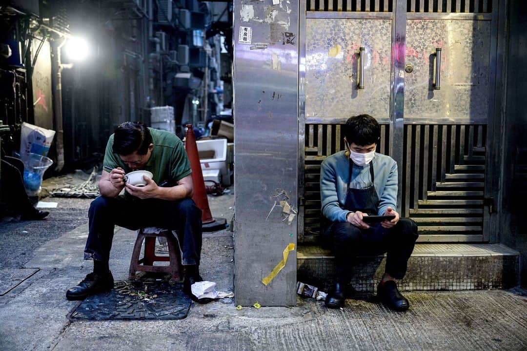 NBC Newsさんのインスタグラム写真 - (NBC NewsInstagram)「A man eats his dinner in an alleyway as another man checks his phone in a residential doorway in Hong Kong.⁠ ⁠ 📷 @antwallace / @afpphoto」1月5日 4時51分 - nbcnews