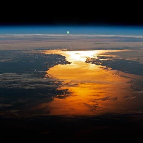 NASAのインスタグラム：「🎵Sun in the sky, you know how I feel 🌅  While each & every sunrise literally marks the beginning of a brand new day, it also reminds us all that we, too, can start fresh with a good attitude, positivity, and gratitude. We are all about that for 2021 and beyond.   In a region often shrouded in clouds, this sunglint photograph was snapped by an Expedition 56 crew astronaut aboard the @ISS who focused a camera lens on the Sun’s reflection point, about 1050 miles to the northeast of the spacecraft’s position over Massachusetts. The photograph shows the horizon and coastline of the Canadian provinces of Newfoundland and Labrador, with Quebec further inland. Flying towards the sunrise looks magical: the feeling of speed, the Earth rotating below and the ISS humming, and then a massive burst of vibrant light. Let's go?  Credit: @NASAJohnson  #NASA #Universe #Sun #Sunrise #NewDawn #MondayMotivation #2021 #Earth #STEM #NewYear2021」
