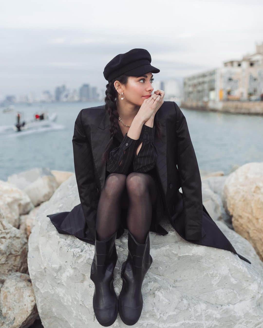 インバー・ラヴィのインスタグラム：「Missing my homeland, missing my people🖤   We shot this right before the pandemic in my beloved port of Jaffa. I’m wearing a traditional Hasidic coat my stylist wore to the shoot that day and a local fisherman’s rubber boots. Both waaay too big for me and from 2 very different worlds, but that’s Israel ; you make it work.」