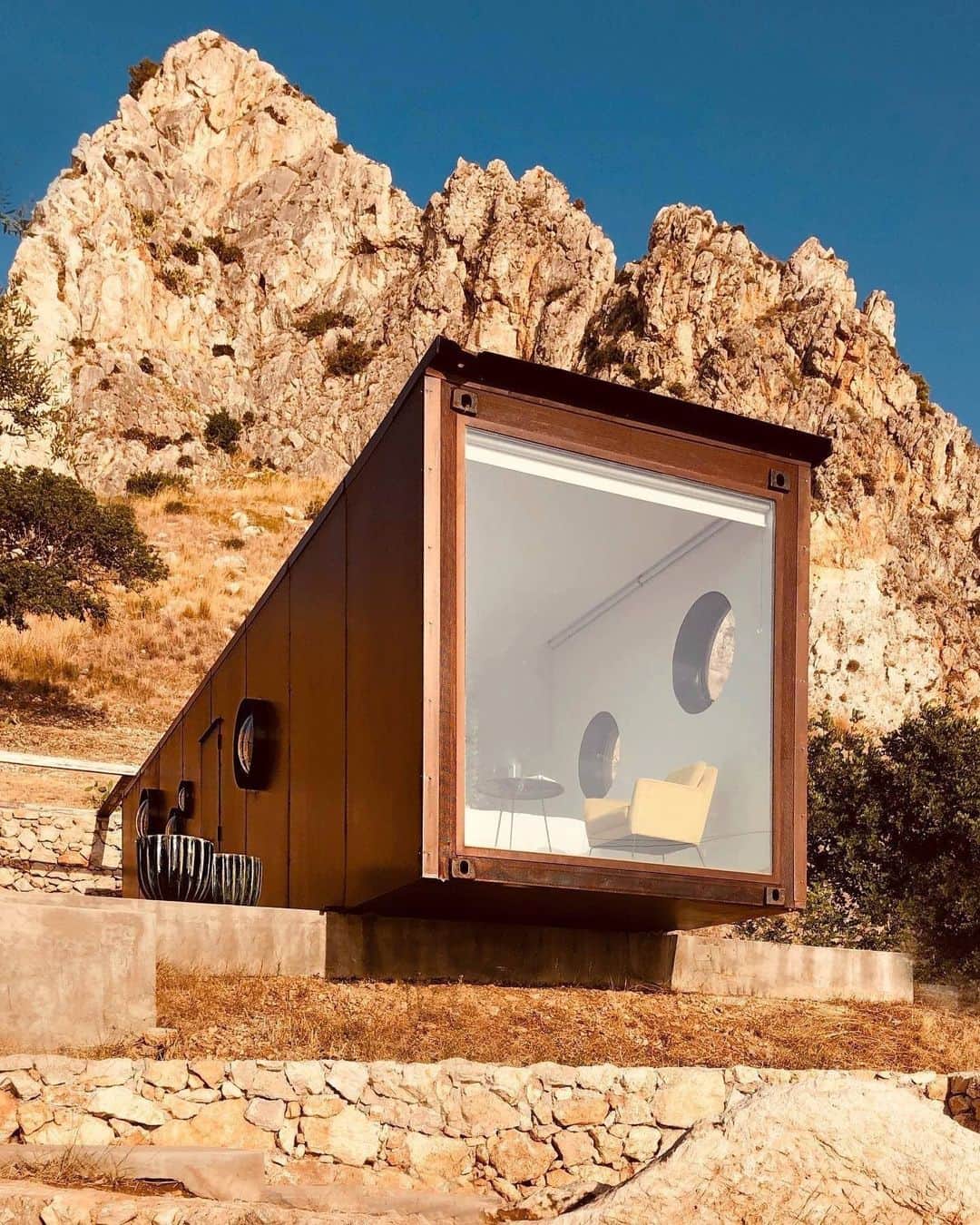 Airbnbのインスタグラム：「Lots of homes are described as being “perched” somewhere, but few take the claim as literally as host Vittorio’s chic container house, high above the Gulf of Castellammare. If you can bring yourself to come down, check out the three historic watchtowers nearby and see if any of them can beat the view from your front window.   Photo: @containersuite」