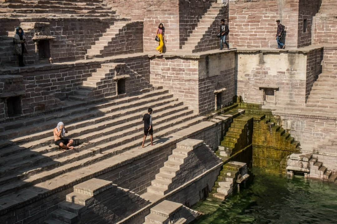 National Geographic Travelさんのインスタグラム写真 - (National Geographic TravelInstagram)「Photo by @francescolastrucci / Like in an Escher drawing, visitors climb up and down the Toorji Ka Jhalra step well in Jodhpur, India. Rajasthan is famous for amazing royal architecture. This intricate step well was built in the early 1740s by the wife of Maharaja Abhay Singh using the famous rose red sandstone found in Jodhpur.  The step well saved the monsoon rainwater for the rest of the year and represented the wisdom and the skills of western India’s inhabitants. Many step wells survive today, despite being replaced by modern water systems. Unfortunately the Toorji Ka Jhalra was neglected, submerged, and filled with garbage for many years. It was recently restored to its former glory as part of a historical and cultural recovery project of the old city.  Follow me @francescolastrucci for more places, daily life, and stories around the world. #india #rajasthan #jodhpur #dailylife」1月6日 20時39分 - natgeotravel