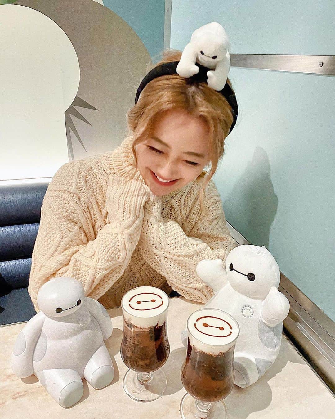のインスタグラム：「🤖🤍🥤﻿ ﻿ ﻿ ﻿ 頭の上のベイマックスと﻿ #ベイマックスアイスカフェモカ を﻿ 覗いているの図👀🥤👱🏻‍♀️🤍🤍⚡️﻿ ☞1杯¥800﻿ ﻿ ﻿ いつもは耳がついている﻿ カチューシャの方が好きなんだけど、﻿ #ベイマックス のカチューシャはお気に入り🤖🤣💕💕﻿ ﻿ ﻿ ﻿ ﻿ おまけに 飲んだ時の動画を🎞🤖 こういう顔がついてるドリンク、﻿ ストロー刺すのに時間かかるんだよね🥺💭﻿ 刺す時にああ…😭！！！ってなる⚡️笑﻿ ﻿ でも混ぜた方が断然美味しいよ😌💕﻿💕 𓂃 𓈒𓏸 ‎𓂃 𓈒𓏸 ‎𓂃 𓈒𓏸 ‎𓂃 𓈒𓏸 ‎𓂃 𓈒﻿ #disneysisters_jp#bighero6#baymax」
