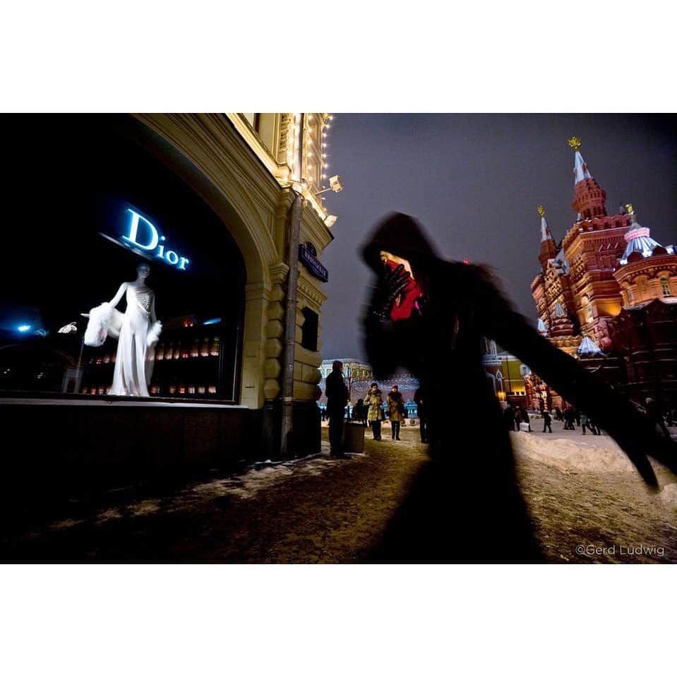 Gerd Ludwigのインスタグラム：「A shopper scythes through the bitter cold to reach a boutique on Red Square. These days, Marx and Lenin can’t compete with Dior and Armani for the hearts of the consuming class.  This photograph was the opening image from my exhibit “Moscow – Winds of Change,” at the Festival La Gacilly-Baden Photo in Austria, where more than 30 exhibits were shown in a beautiful outdoor setting around town.  Out of all the 2,000 images, this large-scale print (measuring 48 x 75 inches) was carefully dismantled and taken by thieves the night before the exhibit was to close. Should I take it as a compliment?  If you are the one who took it, please contact me and let me know if you need it signed!  @thephotosociety @natgeoimagecollection @natgeotravel #Russia #Moscow #RedSquare」