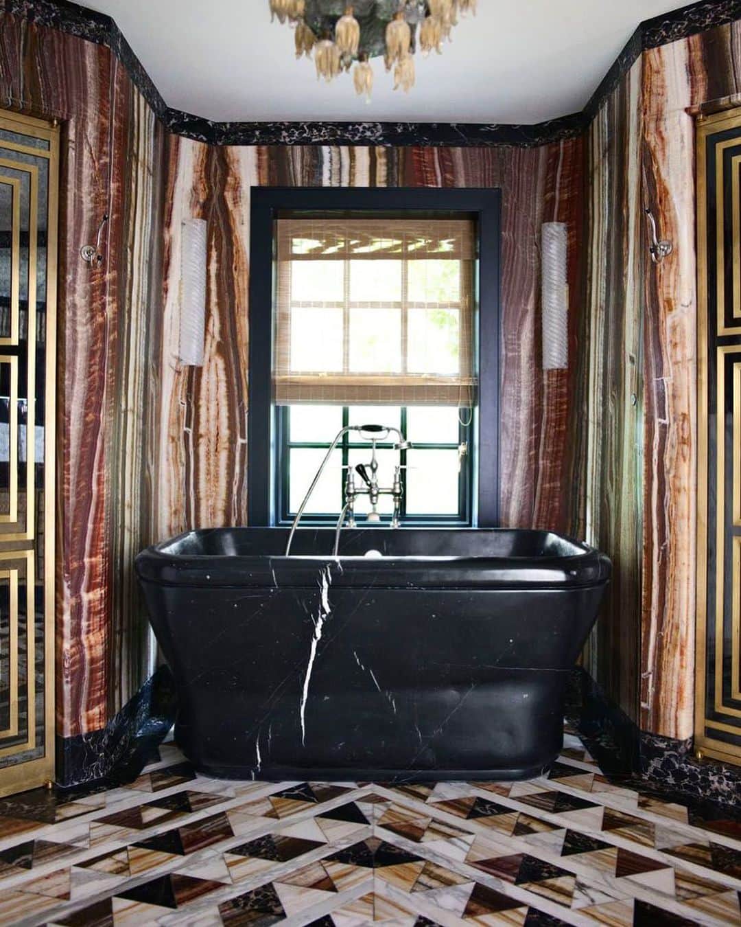 ケリーウェアスラーのインスタグラム：「ONYX FANTASTICO. Even our most private spaces are opportunities for experimenting with bold materials, patterns and colors – as shown in this bathroom. A marble and onyx extravaganza, it features rippling walls, geometric floors and a monolithic black bathtub ideal for relaxing at the end of a day. XK」