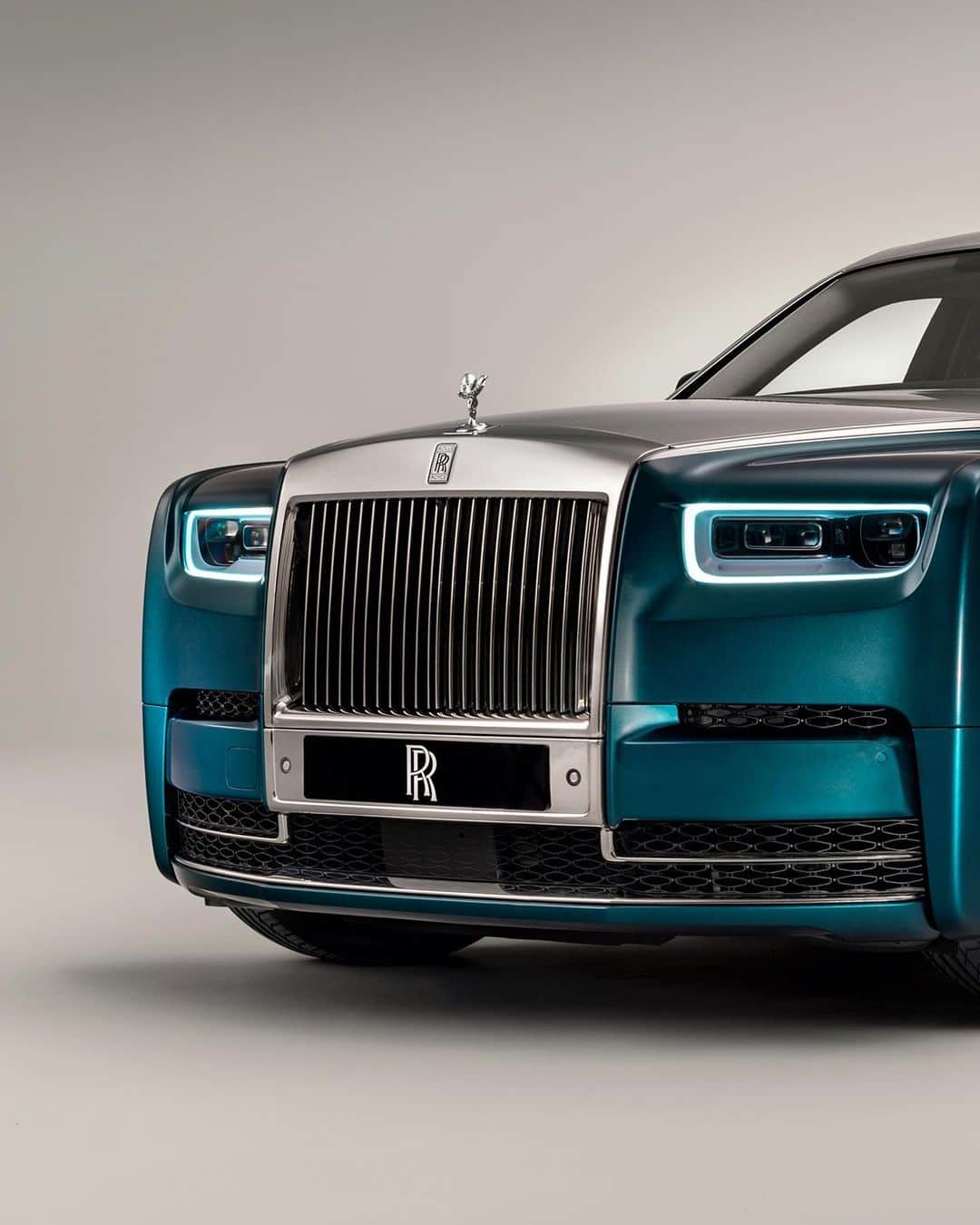 ロールス・ロイスのインスタグラム：「Finished in a two-tone lacquer of Premier Silver and Dark Silk Teal, Phantom Iridescent Opulence evokes the rich, kaleidoscopic colour of a bird's feather.   Discover #RollsRoycePhantom; link in bio.  #RollsRoyceIsBespoke   — NEDC (combined): CO2 emission: 329-328 g/km; Fuel consumption: 19.5-19.6 mpg / 14.5-14.4 l/100km. WLTP (combined): CO2 emission: 356-341 g/km; Fuel consumption: 18.0-18.8 mpg / 15.7-15.0 l/100km.」