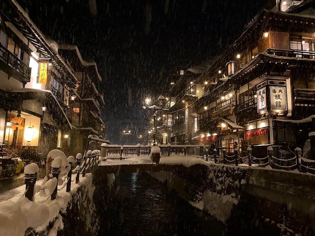 吉江瞳のインスタグラム：「夜の銀山温泉♨️ 灯りが優しくってとってもいい雰囲気☺️❤️ 2枚目は今回の宿藤屋さんの外観😊はい！そうです！外からは丸見えです🤣 でも素敵な宿だった☺️ 夜も白銀の滝見に行ったけどライトアップされて綺麗でした❤️ 雪国で住んでないからこんな綺麗な雪あると大の字で埋もれたい願望が出てくるので飛び込んでみたらフワッフワ😳 ただやった後に寒くて後悔😂笑 #銀山温泉 #夜の銀山温泉 #藤屋 #隈研吾 #雪国 #山形 #よし旅 #よしえの冬休み」