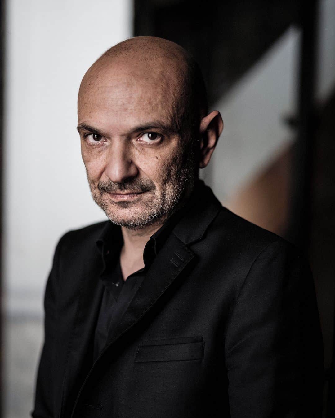 ルモンドのインスタグラム：「Richard Malka prévient d’emblée qu’il n’aime pas parler de lui. « Je dis toujours non aux portraits ; l’autoanalyse, ce n’est pas mon truc », assure l’avocat parisien, tout en malaxant nerveusement des pierres polies d’une main et en tirant sur sa cigarette de l’autre. Par la fenêtre, on devine la présence des policiers chargés de veiller à sa sécurité. L’avocat vit sous protection depuis la tuerie de Charlie Hebdo le 7 janvier 2015. Petit rappel que le courage a un prix et que certains combats se paient cher.⁣ Certains de ses adversaires fustigent son côté « avocat des stars », de Marek Halter à Carla Bruni. Il hausse les épaules. Ce travailleur acharné, prêt à suer sang et eau sur chacune de ses plaidoiries, a toujours pris soin de garder un monde à lui, comme pour mieux se protéger du réel. Auteur d’une vingtaine de BD à succès (800 000 exemplaires écoulés en tout), il s’est donc lancé dans le roman : « Il me faut sans cesse un nouveau défi, une nouvelle frontière. » De tels exercices lui permettent de laisser libre cours à son imagination débordante. « Je suis tout le temps dans mes mondes, à m’inventer des histoires dont je suis le héros. Ecrire me permet de donner un débouché à tout ça. »⁣ « Il y a deux Richard, dit de lui son éditeur, Christophe Bataille. L’avocat juvénile qui aime le combat, la vie, les médias, et celui de ses livres, peuplés de personnages vivant la nuit, qui dévoilent une âme tourmentée. »⁣ -⁣ Richard Malka dans ses bureaux du 8e arrondissement de Paris, le 2 février. Photo : Édouard Caupeil (@edouardcaupeil) #PourLeMonde⁣ -⁣ #litterature」