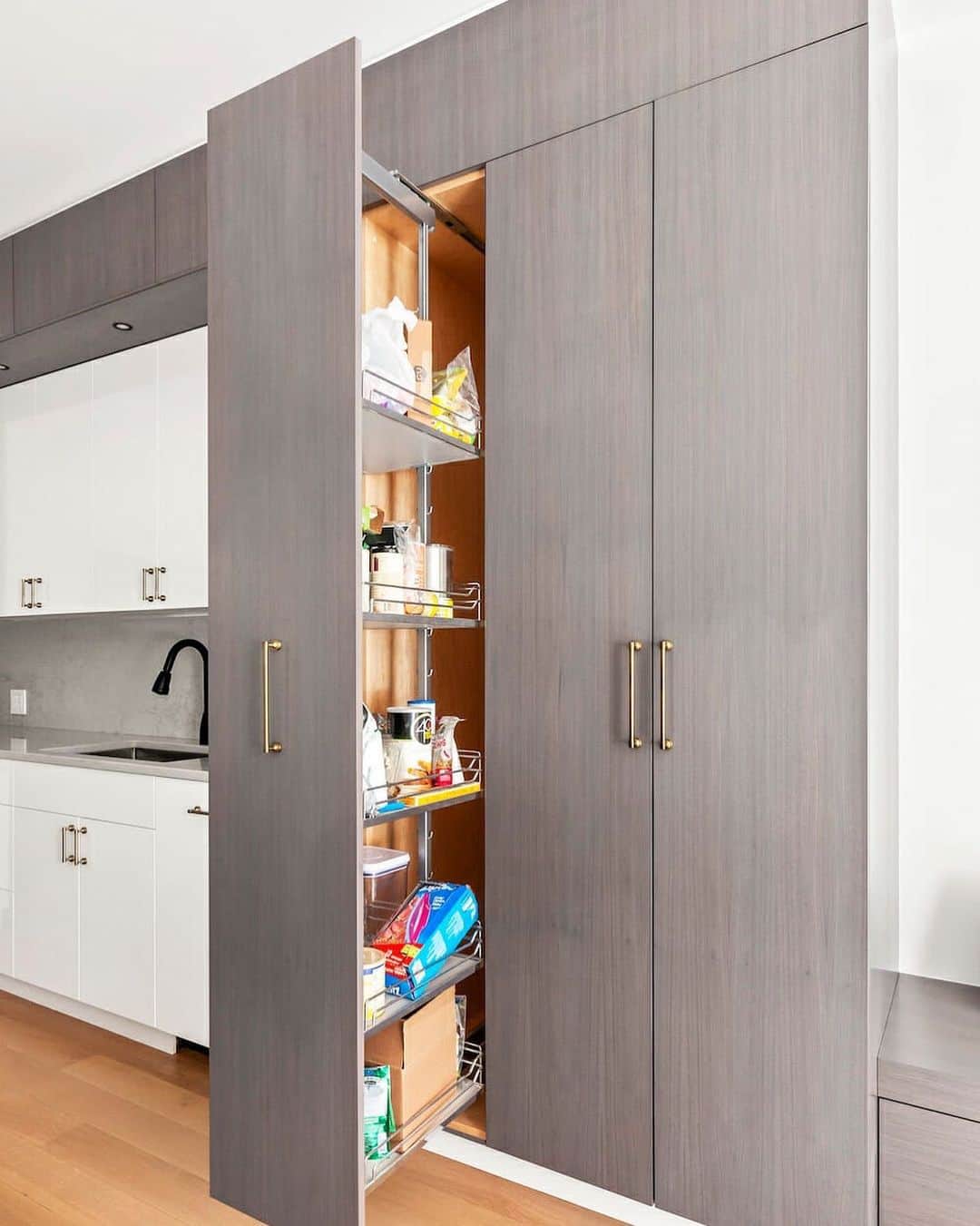 Sweeten Homeのインスタグラム：「An integrated, pull-out pantry and coat closet utilizes every inch of floor-to-ceiling space in this open living room-kitchen NYC apartment 💕」