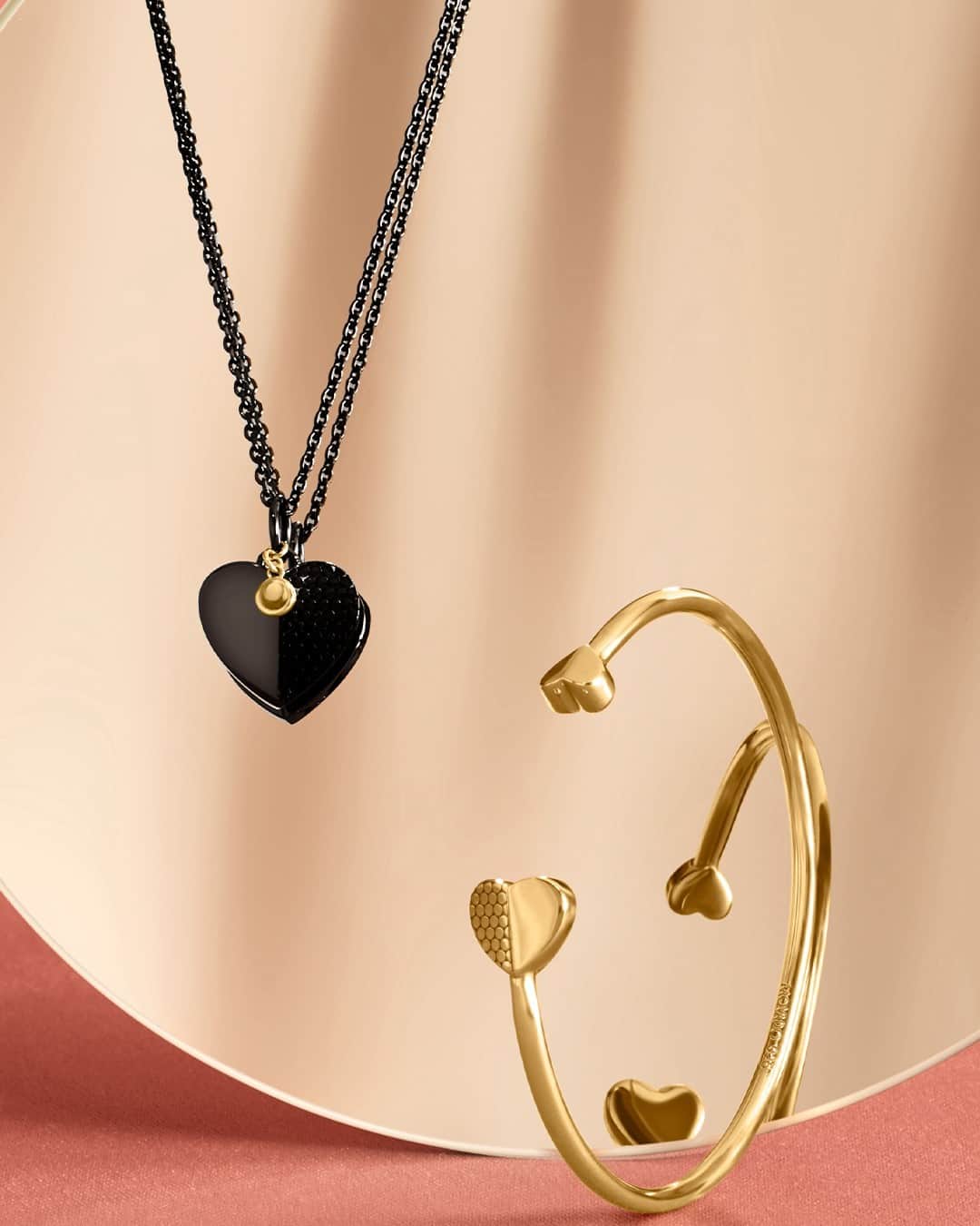 モバードのインスタグラム：「Reflections of modern love. Look chic in our signature black and gold heart collection, which includes necklaces, bracelets, and earrings. Exclusively available on Movado.com. #MovadoJewelry」