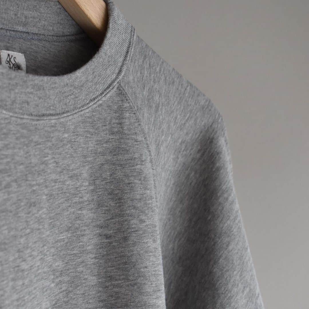 キャプテン サンシャインのインスタグラム：「﻿ "Crewneck Pullover L/S"﻿ ﻿ FETHER GREY / BLACK﻿ ﻿ 表にはスーピマコットン。裏にはスビンコットンを使用したダンボールニット。﻿ 裏毛素材よりも薄く軽く、程良いボリュームに仕上げました。﻿ ﻿ シャリ感のある表に対し肌触りの良い裏面のダブルフェイスで春夏シーズンに最適な1枚。﻿ ハンドウォーマー付き。﻿ ﻿ #kaptainsunshine﻿ #21ss」