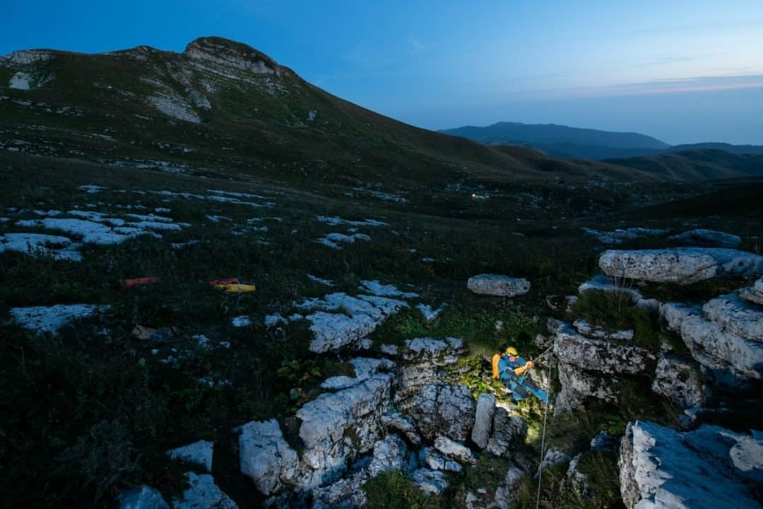 ナショナルジオグラフィックさんのインスタグラム写真 - (ナショナルジオグラフィックInstagram)「Photo by Robbie Shone @shonephoto / This is the unassuming entrance of Veryovkina, the deepest known cave on Earth. We see the surface topography at 2,300m (7,545ft), high up in the Western Caucasus mountains, close to the the Black Sea. The expedition leader, the late Pavel Demidov, is pictured here at the head of the entrance pitch. In the background, the lights of base camp are just visible, as several team members finish off their preparations for two weeks down in the cave.」1月14日 10時36分 - natgeo