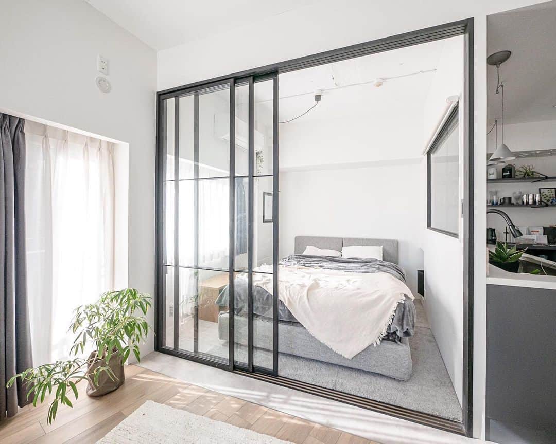 響のインスタグラム：「bedroom 🛏 寝室はベッド置いてギリギリ通れるくらいに設計しました✏️ その分リビングを広くとりたかったので🤔 ・ 狭く感じないように間仕切り戸を大きなアイアンのガラス戸にして開放感を✨ ・ 限られたスペースを有効に使う工夫です😎 ・ 3枚扉→ @theclock_ オリジナルデザイン ベッド→ @songdream_japan  ラグ→ @ikeajapan  サイドボード→ @crashgate_shop  ペンダントライト→ @new_light_pottery  ・ #寝室#ベッド#アイアン#採光窓#室内窓#リノベーション#インテリア#建築#デザイン #bed#bedroom」