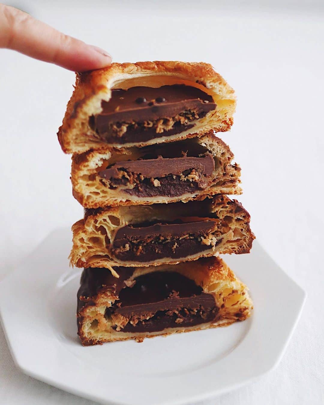 樋口正樹さんのインスタグラム写真 - (樋口正樹Instagram)「chocolate danish . おやつの時間にコーヒーと アンデルセンの冬の定番の チョコレートのデニッシュ。 人気らしいので食べてみた。 . ２４層のデニッシュ生地に 下からチョコのカスタード、 フィアンティーヌ←ザクザクのやつ！ さらにチョコレートを重ね、 シリアルチョコを飾ってて、 絶対おいしいやつでしたー。 @andersen_official_jp . . ２枚目は、縦半分に切って ２４層を４段に重ねてみて、 ９６層に積み上げてみたよ。 ぜんぶひとくちで食べたら サクサクサクサクサクサク サクサクサクサクサクサク サクサクサクサクサクサク サクサクサクサクサクサク サクサクして、たぶん最高🤗 . . #サクサク #おやつの時間 #コーヒーブレイク #チョコレートデニッシュ #デニッシュ #デニッシュペストリー #チョコレート #チョコレートたっぷり #コーヒーのお供 #断面 #ファイアンティーヌ #アンデルセン #アンデルセンのパン #パンのある暮らし #パンのある生活 #パンスタグラム #パン大好き #ヒュッゲ #ステイホーム #andersen #chocolatedanish #hygge #danish #bread #bakery #copenhagen #bageri #denmark #breadlover #🇩🇰」1月15日 14時44分 - higuccini