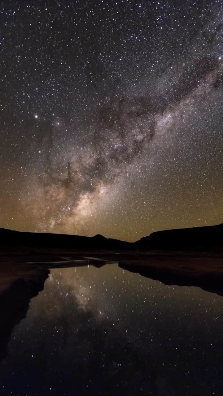 のインスタグラム：「A window to the universe. The rotating Earth turns our view of the galaxy as science photographer @babaktafreshi spent a cold and magical starry night at an altitude of 4,500 meters (15000 ft) in the Altiplano, on the border of Chile and Bolivia. The slightly frozen water reflects the rising Milky Way in the time-lapse video, made for the Borderless Sky documentary series (for Arte & ZDF) about the World at Night project, a long-term effort by Babak and international team of photographers to reconnect us with the wonders of the night sky and the value of preserving the natural night environment. Learn more @twanight and @babaktafreshi.」