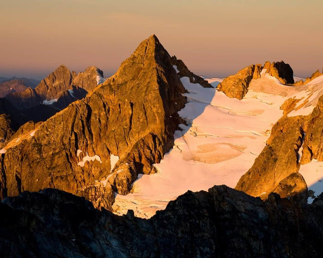 National Geographic Travelさんのインスタグラム写真 - (National Geographic TravelInstagram)「Photo @stephen_matera / Sunrise on the Southern Picket Range in late summer, deep in the North Cascades of Washington State. The Pickets are a remote and extremely rugged subrange of the North Cascades, with 21 peaks over 7,500 feet and multiple glaciers. Peak names are appropriately named for the awe and fear they inspire in climbers—names like Mount Fury, Terror, Challenger, and Phantom. Follow me @stephen_matera for more images like this from Washington and around the world. #wilderness #picketrange #northcascades」1月16日 4時37分 - natgeotravel