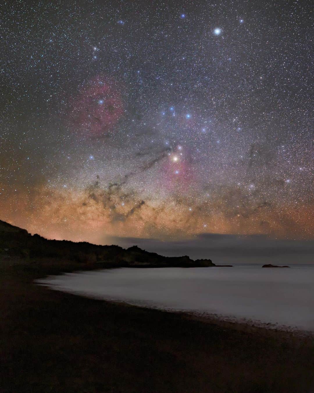 のインスタグラム：「Photos by @babaktafreshi / I'm often asked whether my images of the night sky show what we can see with the naked eye. In some cases they come close, and in others, like this one, the scene is far beyond our limits (I used an astrophotography camera to reveal the large, faint nebulae). Swipe to see a comparison of what you might have seen on this May night in the Canary Islands. While the colors disappear, under a natural moonless night sky like this, far from light pollution, the Milky Way is still spectacular, especially between April and October—and even better in the tropics and Southern Hemisphere. Although the galaxy is prominent to the naked eye, we are almost colorblind at dark, except where there are strong sources of light, such as brighter stars or intense aurora. The camera’s long exposure reveals these hidden but true colors. There is a physical explanation for every color in this image. The camera also reveals many more background stars that we can see, but still you're able to see more than a thousand! On my website babaktafreshi.com/darksky learn where to find a dark place near you. #twanight #darksky #astrophotography #milkyway」