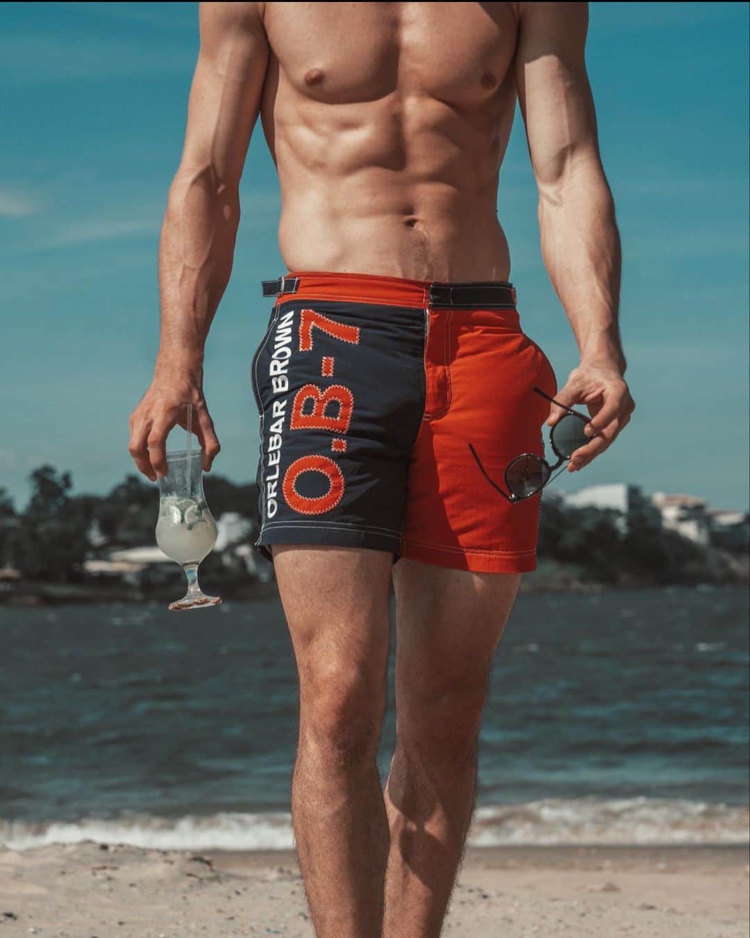 オールバーブラウンのインスタグラム：「You can still shop OB Weekender, the bold capsule defined by chunky stitching, unapologetic branding & contrast zips (link in bio). Tap to shop our branded Weekender Bulldog swim shorts, as worn by @MarcelFloruss for a stroll in the Brazilian sunshine. In case you wondered, the ‘7’ honours our founding year (2007). 🔴🔹🔺🔷 #OrlebarBrown  #OBsAroundTheWorld」