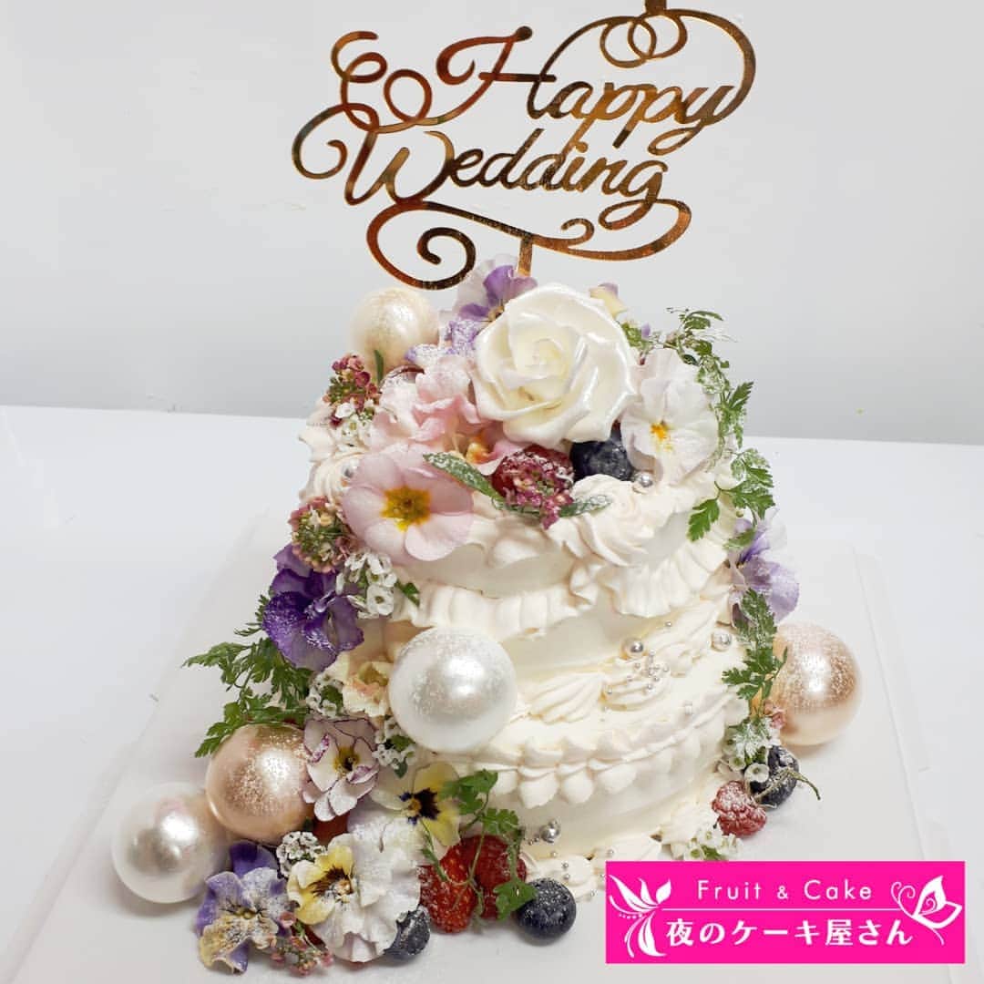 のインスタグラム：「前回投稿したプロポーズケーキの反響たくさん😳💒💓 : 連日コロナのニュースがたくさんですが、暗いニュースばかりでなく、日々の幸せを大切に前向きに暮らしていきたいですね😌💕 : 彼からのNONYさんへのプロポーズ大成功ということで、 今度はNONYさんリクエストで、おふたりだけのウェディングケーキを💒💗 お互いを想いあってるお二人に、いつも温かい幸せをお裾分けしてもらってます😚 : 挙式はすぐには出来ないかもってことで、まずはふたりでおうちでお祝いするためのウェディングケーキをリクエストいただいて💕お作りしました💗 白いケーキに、エディブルフラワーをたくさん飾って…🌿 : 過去におふたりで食べるために頼んでいただいたケーキも投稿しました💕 スワイプしてくださいね↔ : 最後の写真はクリスマスプレゼントのジュエリー💎✨嬉しい😭✨ 私の写真が下手すぎるので、NONYさんのジュエリーのInstagram見てください💎💕 @jewelilytokyo 愛に溢れたオーダーメイドのジュエリーで、TVや雑誌でも話題～😳💓 : : #jewelilytokyo #夜のケーキ屋さん」