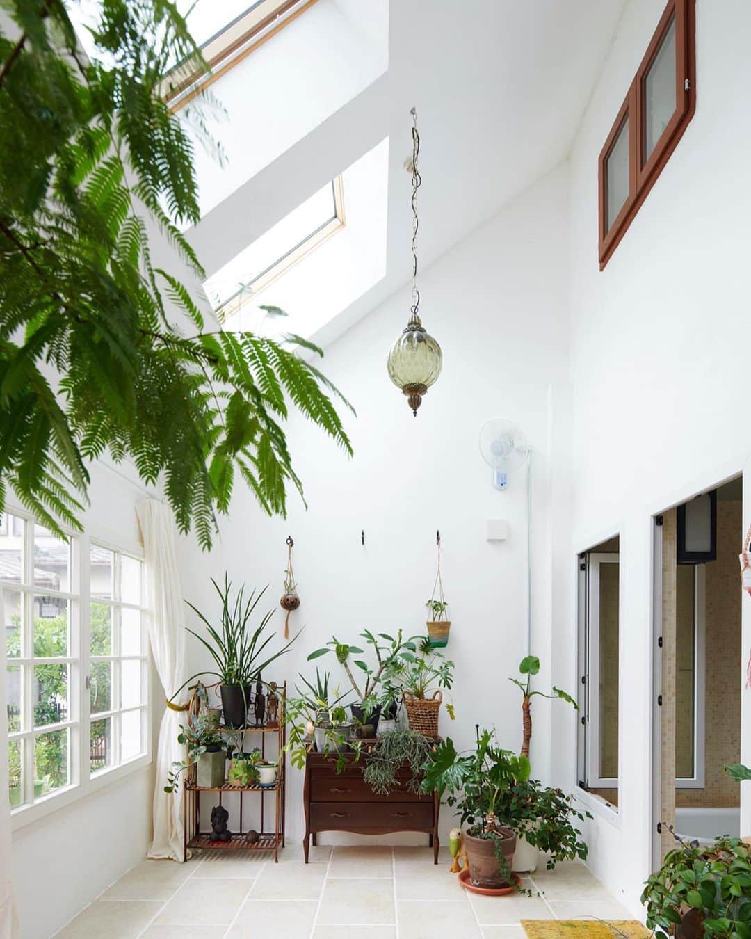 feve casaのインスタグラム：「【 秘密の花園を家に 】  三角屋根を冠した白い外観は、まるでおとぎ話に出てくる家のようなG邸。  内と外の中間領域である「コンサバトリー」は、陽光に満ちて緑がいきいきと育つ、とっておきのリラックス空間でふ。  自宅にこんなスペースがあったら、飽きずに1日中居てしまいそう。  住み手のセンスが光るこなれたインテリアも必見です。  🌳設計施工　エーティーエム建築 @atm.koumuten  🌳重量木骨の家 @mokkotsu  #コンサバトリー #カントリースタイル #カントリー #カントリーインテリア #カントリーキッチン #ガーデニング #三角屋根 #三角屋根の家 #庭のある家」