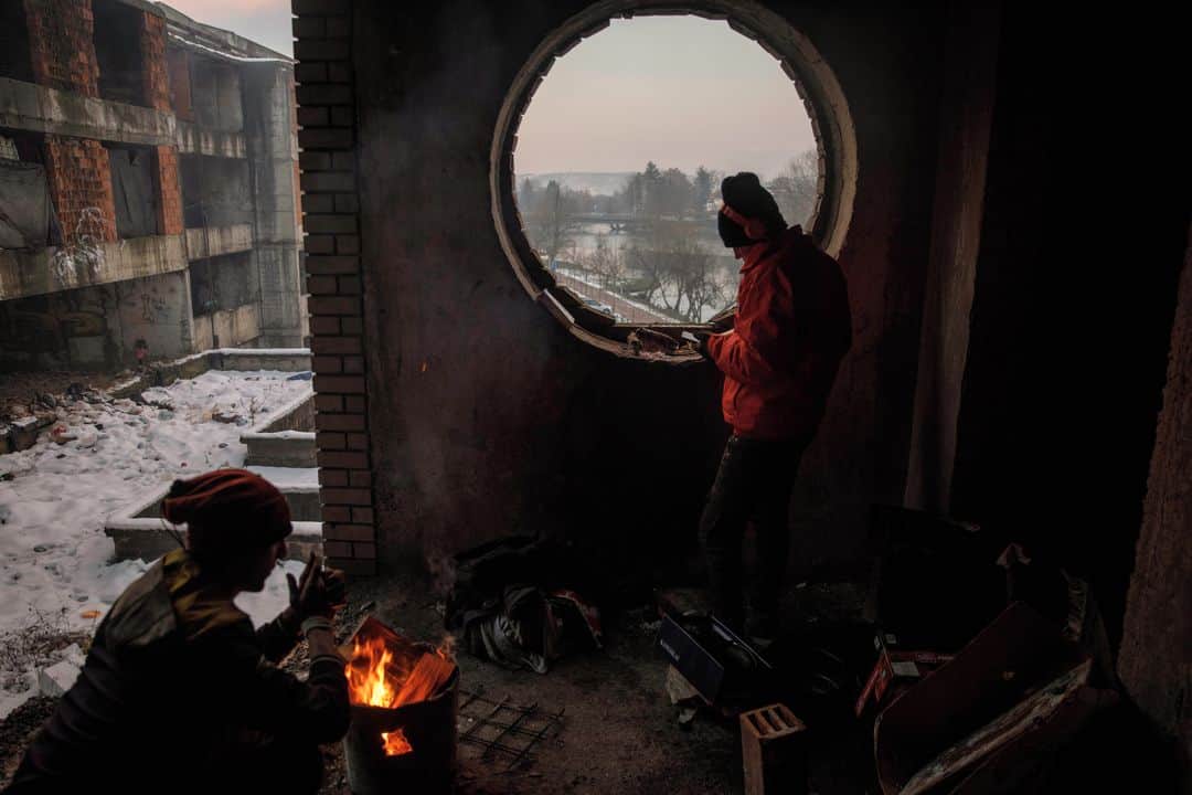 ルモンドさんのインスタグラム写真 - (ルモンドInstagram)「Les années passent et, autour de Bihac, dans le nord-ouest de la Bosnie-Herzégovine, sur l’axe de la principale route migratoire à travers les Balkans, la situation continue de se détériorer, hiver après hiver.⁣ Recroquevillé devant un poêle à bois dans l’usine désaffectée Krajinametal, Aslan raconte en tremblant de froid qu’il en est à sa dix-huitième tentative de passage vers l’UE. Pour cet Afghan de 17 ans, le « game » comme l’appellent les migrants, le « jeu » qui consiste à tenter de traverser la frontière croate, est presque devenu une routine : cela fait deux ans qu’il est sur la route d’Afghanistan vers l’Europe, et sept mois qu’il est arrivé en Bosnie.⁣ Il dort sur un matelas gorgé d’humidité et de suie, l’usine désaffectée ayant brûlé il y a quelques années. Il existerait environ cent cinquante squats dans le canton d’Una-Sana, pour une population d’environ 8 000 migrants actuellement. Certains sont de simples maisons en construction occupées près de la frontière, d’autres des camps de fortune éparpillés dans la nature. L’un des plus infâmes est le camp surnommé « Little Bangladesh », perdu dans une forêt à Siljkovaca.⁣ -⁣ 1 : Un migrant afghan se lave par -10°C, près du camp de Bihac, le 16 janvier⁣ 2-7 : Des migrants afghans dans un squat à Bihac le 14 janvier⁣ 3 : Un « camp de jungle » installé par des migrants du Bangladesh, près de Velika Klaus, le 15 janvier⁣ 4 : Une famille afghane renvoyée en Bosnie par la police croate alors qu’elle tentait de pénétrer dans l’UE, à Bosanska Bojna⁣ 5 : Une distribution de nourriture au camp de Lipa, incendié et détruit, géré par des agences bosniennes et internationales dans les montagnes près de Bihac,le 16 janvier⁣ 6 : Aslan, migrant afghan de 17 ans, dans un squat à Bihac le 14 janvier⁣ -⁣ Photos : Damir Sagolj (@damirsagolj) #PourLeMonde⁣ -⁣ #Bosnie #migrants #immigration」1月19日 0時05分 - lemondefr