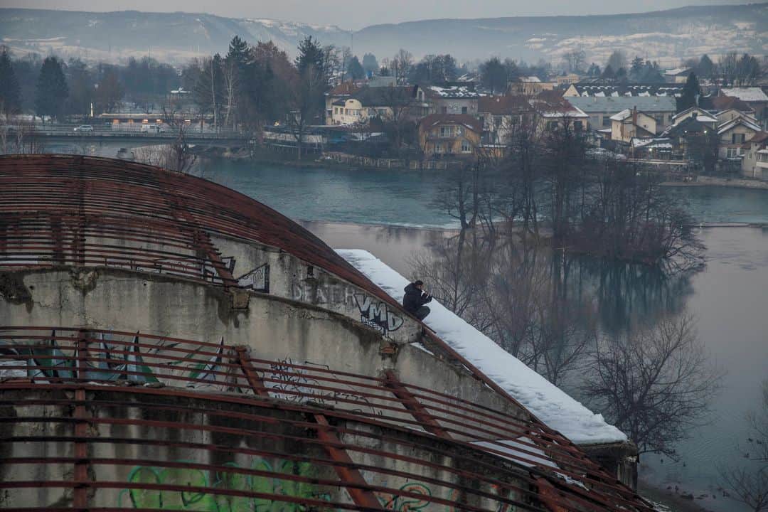 ルモンドさんのインスタグラム写真 - (ルモンドInstagram)「Les années passent et, autour de Bihac, dans le nord-ouest de la Bosnie-Herzégovine, sur l’axe de la principale route migratoire à travers les Balkans, la situation continue de se détériorer, hiver après hiver.⁣ Recroquevillé devant un poêle à bois dans l’usine désaffectée Krajinametal, Aslan raconte en tremblant de froid qu’il en est à sa dix-huitième tentative de passage vers l’UE. Pour cet Afghan de 17 ans, le « game » comme l’appellent les migrants, le « jeu » qui consiste à tenter de traverser la frontière croate, est presque devenu une routine : cela fait deux ans qu’il est sur la route d’Afghanistan vers l’Europe, et sept mois qu’il est arrivé en Bosnie.⁣ Il dort sur un matelas gorgé d’humidité et de suie, l’usine désaffectée ayant brûlé il y a quelques années. Il existerait environ cent cinquante squats dans le canton d’Una-Sana, pour une population d’environ 8 000 migrants actuellement. Certains sont de simples maisons en construction occupées près de la frontière, d’autres des camps de fortune éparpillés dans la nature. L’un des plus infâmes est le camp surnommé « Little Bangladesh », perdu dans une forêt à Siljkovaca.⁣ -⁣ 1 : Un migrant afghan se lave par -10°C, près du camp de Bihac, le 16 janvier⁣ 2-7 : Des migrants afghans dans un squat à Bihac le 14 janvier⁣ 3 : Un « camp de jungle » installé par des migrants du Bangladesh, près de Velika Klaus, le 15 janvier⁣ 4 : Une famille afghane renvoyée en Bosnie par la police croate alors qu’elle tentait de pénétrer dans l’UE, à Bosanska Bojna⁣ 5 : Une distribution de nourriture au camp de Lipa, incendié et détruit, géré par des agences bosniennes et internationales dans les montagnes près de Bihac,le 16 janvier⁣ 6 : Aslan, migrant afghan de 17 ans, dans un squat à Bihac le 14 janvier⁣ -⁣ Photos : Damir Sagolj (@damirsagolj) #PourLeMonde⁣ -⁣ #Bosnie #migrants #immigration」1月19日 0時05分 - lemondefr
