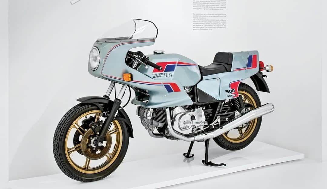 Ducati Japanさんのインスタグラム写真 - (Ducati JapanInstagram)「Ducati Heritage/500 パンタ  1979年に発売した500 パンタ。近代ドゥカティLツインマシンの歴史は、ここから始まりました。  クランクに繋がったベベルギアを介して吸排気バルブを駆動していたドゥカティL型2気筒エンジンの第一世代からバトンを受け取った新型エンジンを搭載。  “パンタ“と名付けたそのエンジンは、ベルトでバルブを駆動するほか新しい技術を多数採用して高回転化と軽量コンパクト化を実現し、スポーツ性も高めました。同時に生産の効率化とともに、高い耐久性と静粛性を手に入れ、二輪車製品としての商品力も高めました。  そして、その後のドゥカティのアイデンティティとなったトレリスフレームを採用。そのエンジンとフレームの組み合わせは、ドゥカティの歴史的モデルを数多く手掛けたファビオ・タリオーニによって生み出されました。  この500 パンタをベースにしたTT-F2仕様のレーシングマシンに乗ったトニー・ラッターが1981年のマン島TTで優勝。その活躍によってドゥカティのファクトリーチームに招き入れられたラッターは、ファクトリー仕様のパンタ・レーサーでTT-F2世界選手権で4年連続チャンピオンとなりました。  #ドゥカティいいじゃん #DucatiHeritage」1月19日 12時00分 - ducatijapan