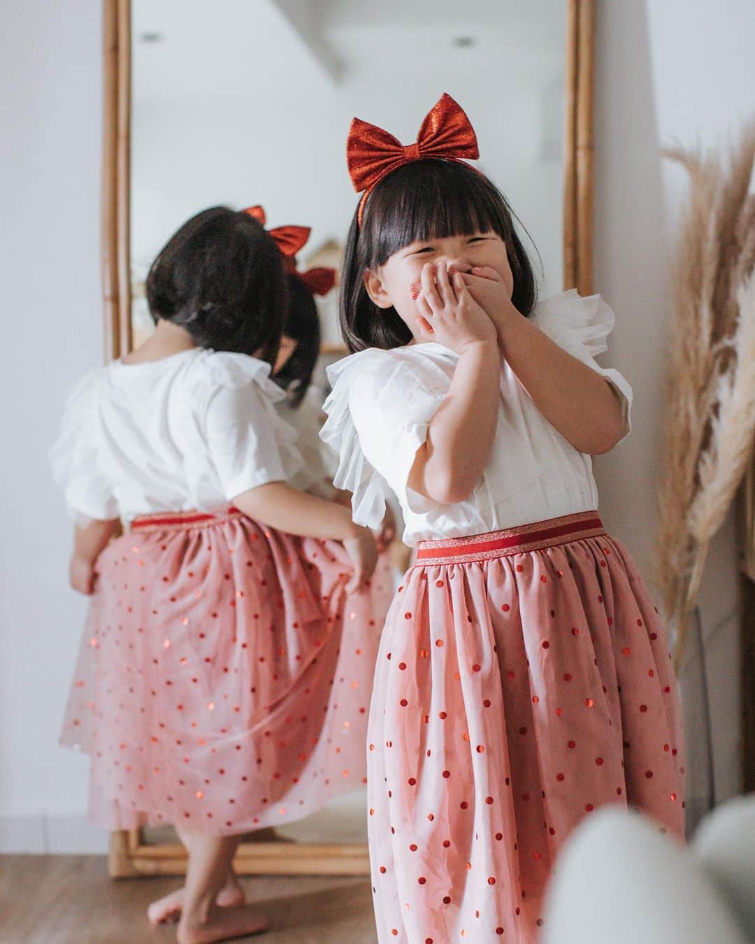 MOMOツインズのインスタグラム：「Their personalities shining through here- Leia is cheeky and free-spirited, Lauren always busy perfecting, in this instance, her ballet move in the mirror.  We are less than a month away from Chinese New Year! Spring cleaning is a last-minute affair, but hey, at least we got our plants and outfits sorted 😜  Here are some looks from the H&M CNY collection.  Use code ‘LLHM15’ for 15% off purchases from their online store hm.com #HMSingapore #HMCNY2021 #sp」