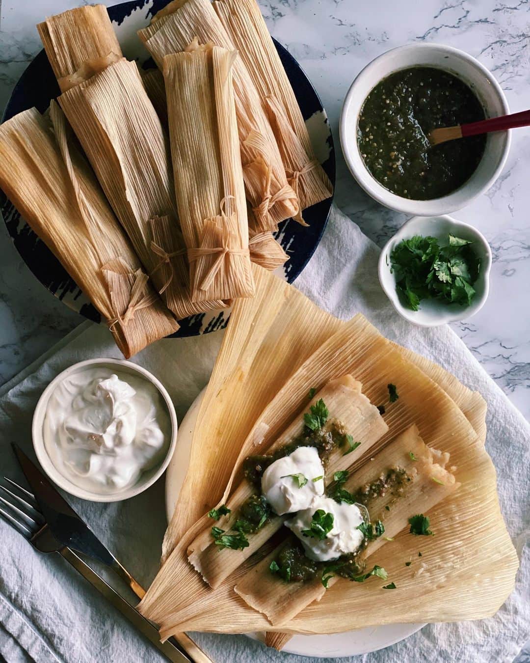 Antonietteのインスタグラム：「Tamales are usually prepared on big occasions or holidays, but why wait? With the way how things are going these days ya gotta live today like there’s no tamale. 😆 or more like 😒? These tamales de rajas con queso (cheese and roasted poblano peppers) are perfect for #meatlessmonday or any day really! 😋 This version is not too hard but takes some time for prep and cooking.  . . TAMALES DE RAJAS CON QUESO  DOUGH 3 1/4 cups instant corn masa 2 1/2 teaspoons salt 1 1/2 teaspoons baking powder 1 cup vegetable oil  2 1/4 cups veggie or chix broth  FILLING 12 ounces cheese cut into thick strips. I used Monterey Jack and queso fresco 5 large poblano peppers roasted and cut into strips  1/2 packet corn husks (about 24)  PREPARATION  Place the husks in a large bowl and fill with hot water, let it soften for an hour.   MAKE THE DOUGH Combine instant corn masa flour salt, baking powder, oil and broth until dough is wet and is cohesive. Let it sit for half an hour.  FILL AND WRAP THE TAMALES  On a corn husk spread a spoonful of the masa onto the bottom half of the husk.  Place roasted chiles and some cheese.   Fold sides in and fold over bottom edge and tie tamale with a piece of corn husk.   Steam tamales upright in a steamer pot, cover and steam for an hour to an hour and a half until dough is fully cooked. Careful as the tamale parcels are hot! 🔥」