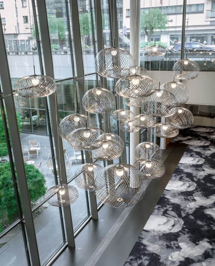 トム ディクソンのインスタグラム：「A massive cluster of SPRING lights. ⁠ ⁠ Our @design_research_studio created the interiors for the @pullmanbercy in Paris. ⁠ ⁠ Filling the (over) double height atrium with the space filling SPRING pendants and partially covering the floor with the SMOKE carpet design by Tom Dixon alongside @egecarpets.⁠ ⁠」