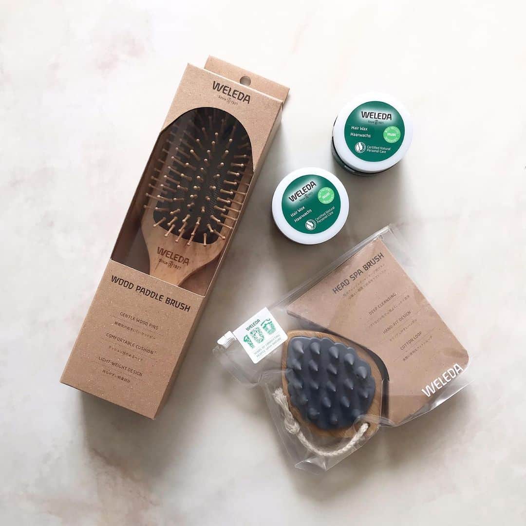 Michikoのインスタグラム：「________ HEAD/HAIR CARE ✔️ . @weleda_japan の健やかな頭皮に着目した 日本開発処方のオーガニックヘアケアライン。 発売したばかりの新製品を購入。  #ヘアワックス (天然由来成分100％の高保湿バーム) 自然な艶とウェット感を与える オーガニックヘアワックス。  ハンド・ネイル・リップ等のパーツケアにも使えるから  ”ながらケア” にも最適。 配合成分やテクスチャー、香り、全て気に入ったため ２つ購入しました。 好みのヘアワックスに出会えて嬉しい❤︎  #ウッドパドルブラシ (頭皮マッサージ用) 軽さと持ちやすさを追求した天然木のパドルブラシ。 クッション性のあるやさしい肌あたりなのに、 頭皮の血行促進をサポートしてくれるとか。 浴室に持ち込めるのも嬉しい。  #ヘッドスパブラシ 水に強い竹材とエコ素材を使用。 柔らかでコシがある心地よい刺激。 頭皮クレンジングやシャンプーと一緒に使うと 気持ちがいいです。 . ブラシ類は、森林認証を取得しているそう🌏🌱🕊 . . #WELEDA #ヴェレダ#WELEDA100周年  .」