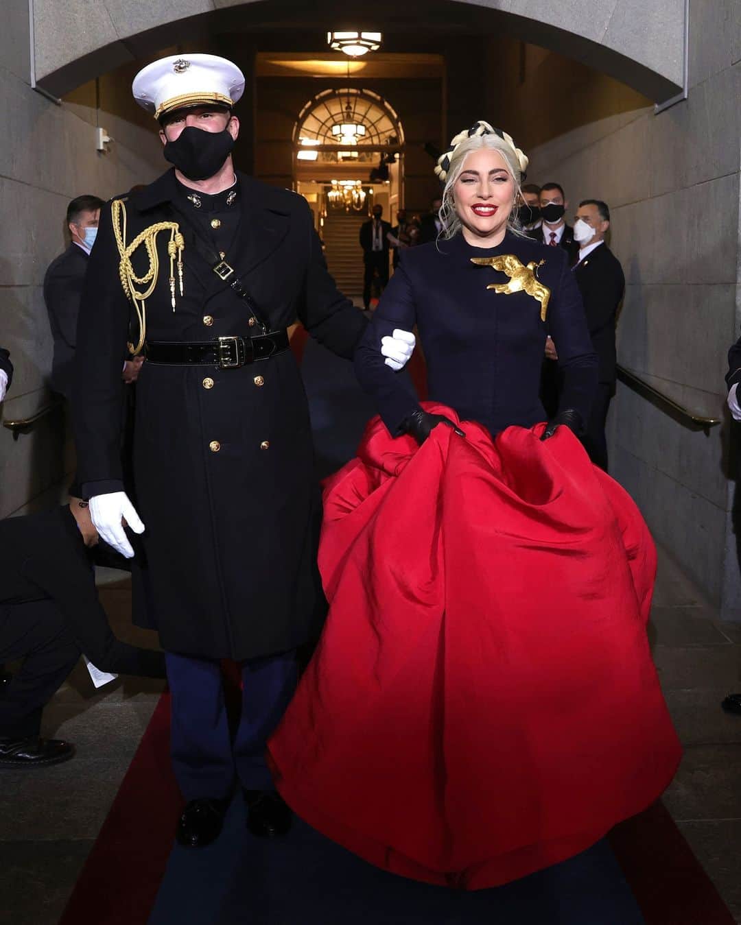 British Vogueさんのインスタグラム写真 - (British VogueInstagram)「On a day centred on new beginnings and the promise of a united future, #LadyGaga's fantastical gown managed to capture the prevailing sense of hope. The singer enlisted an American couturier to create a one-of-a-kind look especially for the inauguration, where she sang the national anthem. Texas-born @DanielRoseberry, who serves as the artistic director of storied French house @Schiaparelli, designed the custom ruffled crimson skirt and suiting-inspired bodice she wore for the occasion. Elegant, arresting and emphatically Gaga, click the link in bio for more on the dress that reflected the spirit of the moment.   @LadyGaga escorted by U.S. Marine escort Capt. Evan Campbell.」1月21日 3時20分 - britishvogue