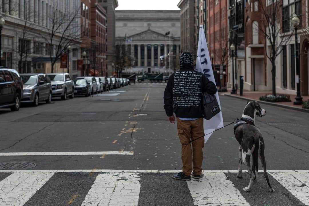 のインスタグラム：「Photo by @johnstanmeyer / Frustrated by all the anger he was seeing on television, Richie Able (and his Great Dane, Lucy) holds a solo demonstration for peace facing the Navy Memorial near the Capitol Building in Washington, D.C., moments before Biden is sworn into office. His jacket is painted with sayings by Buddha and passages from the Bible.」