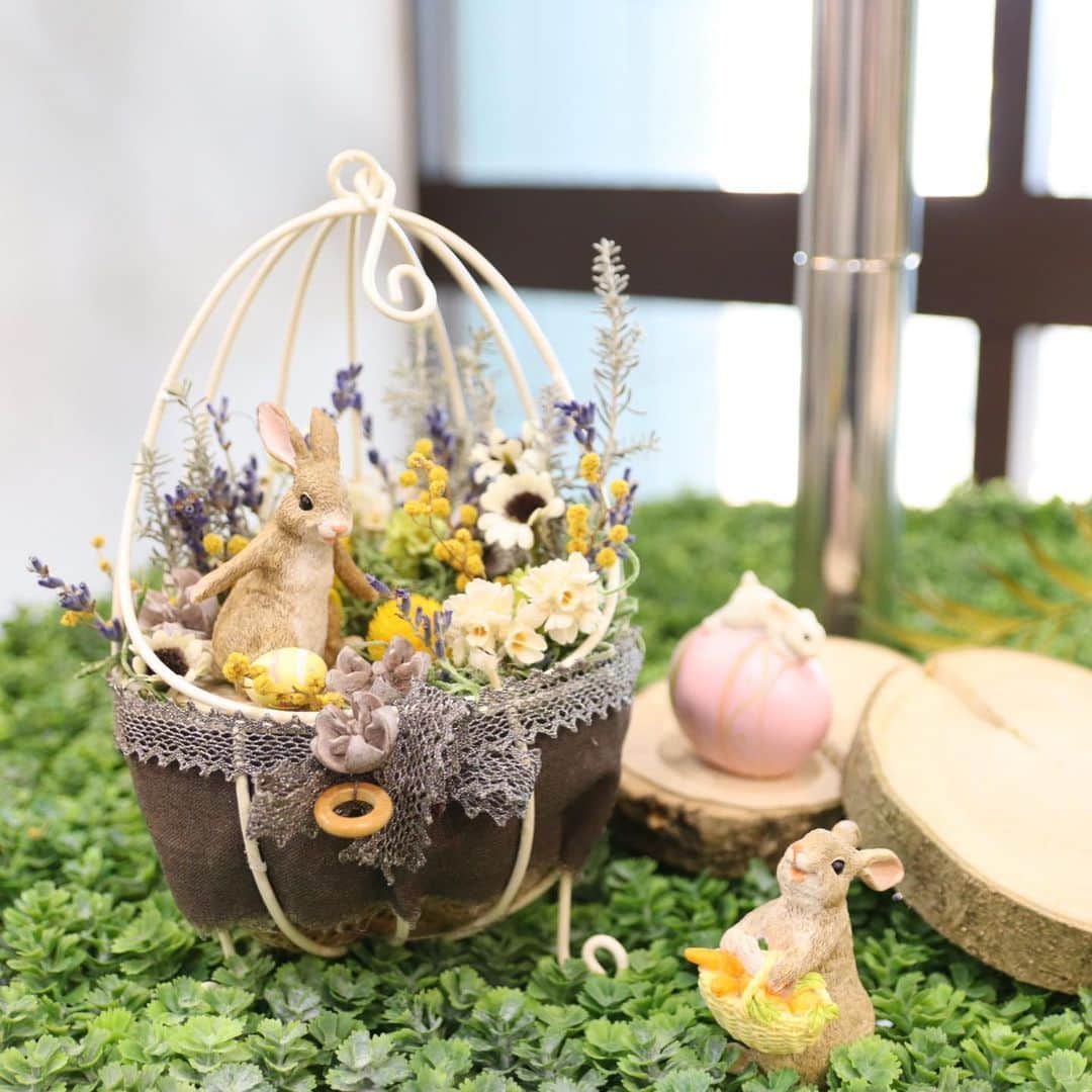 横浜ディスプレイミュージアムのインスタグラム：「. 二階ドライ売場より新商品のご紹介です♪  イースターに向けた商品が入荷いたしました🥚💕  ウサギの置物だけでなく、 エッグ型のベースなどもご用意しております🐰🌟  写真はミニチュアの世界観を表現してみました♪ 造花やドライフラワーとの相性もばっちしです💕  イースターはもちろん、 いつものアレンジやディスプレイに足してみてはいかがでしょうか✨  うさぎ　　　　　　　各¥780+tax ワイヤーエッグ大　　　¥800+tax  #横浜ディスプレイミュージアム #株式会社ポピー #横浜 #ディスプレイ#アーティフィシャルフラワー #フラワーアレンジメント #フラワーデザイン #インテリア雑貨 #インテリア#インテリアコーディネート#スタイリスト#装飾#デコレーション#花のある暮らし #花好きな人と繋がりたい #春アレンジ #春 #イースター #うさぎ #ミニチュア #ジオラマ #display #yokohama#flowerarrangement #interiordesign #artficialflower #flowerstagram」